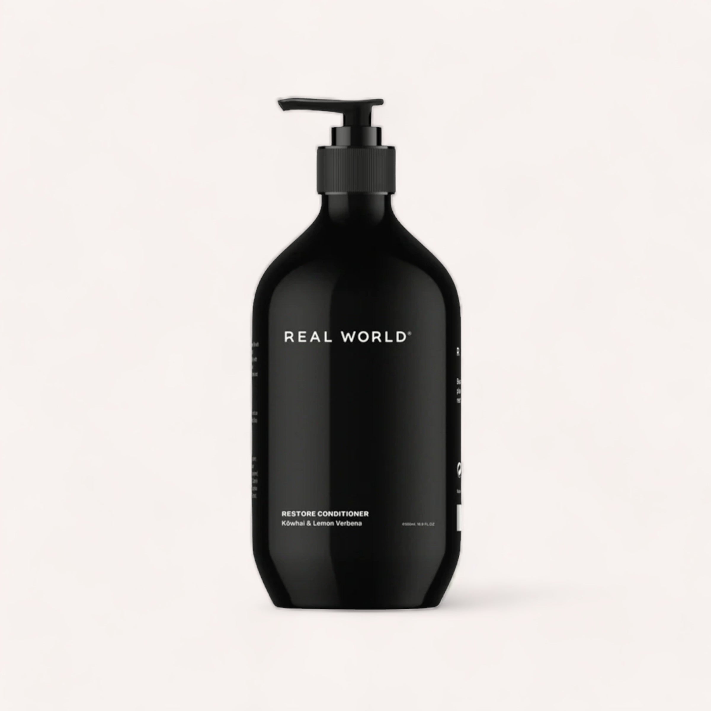 Minimalist design black bottle of 'Real World' Conditioner, a plant-based refillable conditioner, against a plain background.