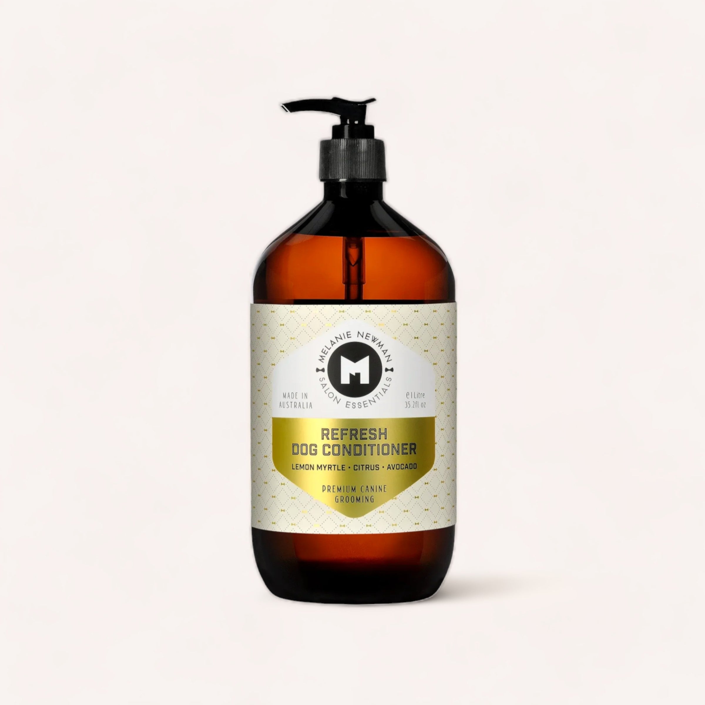A pump bottle of dog conditioner with a minimalist design, labeled "Refresh Dog Conditioner - Australian lemon myrtle, citrus & avocado oil," positioned against a clean, white background by Melanie Newman.