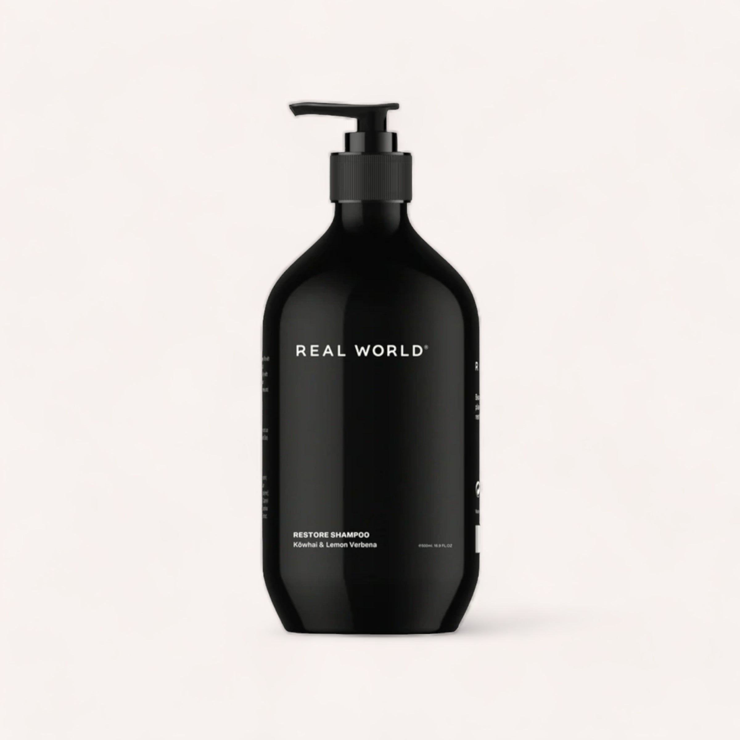 A black pump bottle labeled "Real World" with text indicating it contains Real World Shampoo with activated charcoal, placed against a clean, white background.