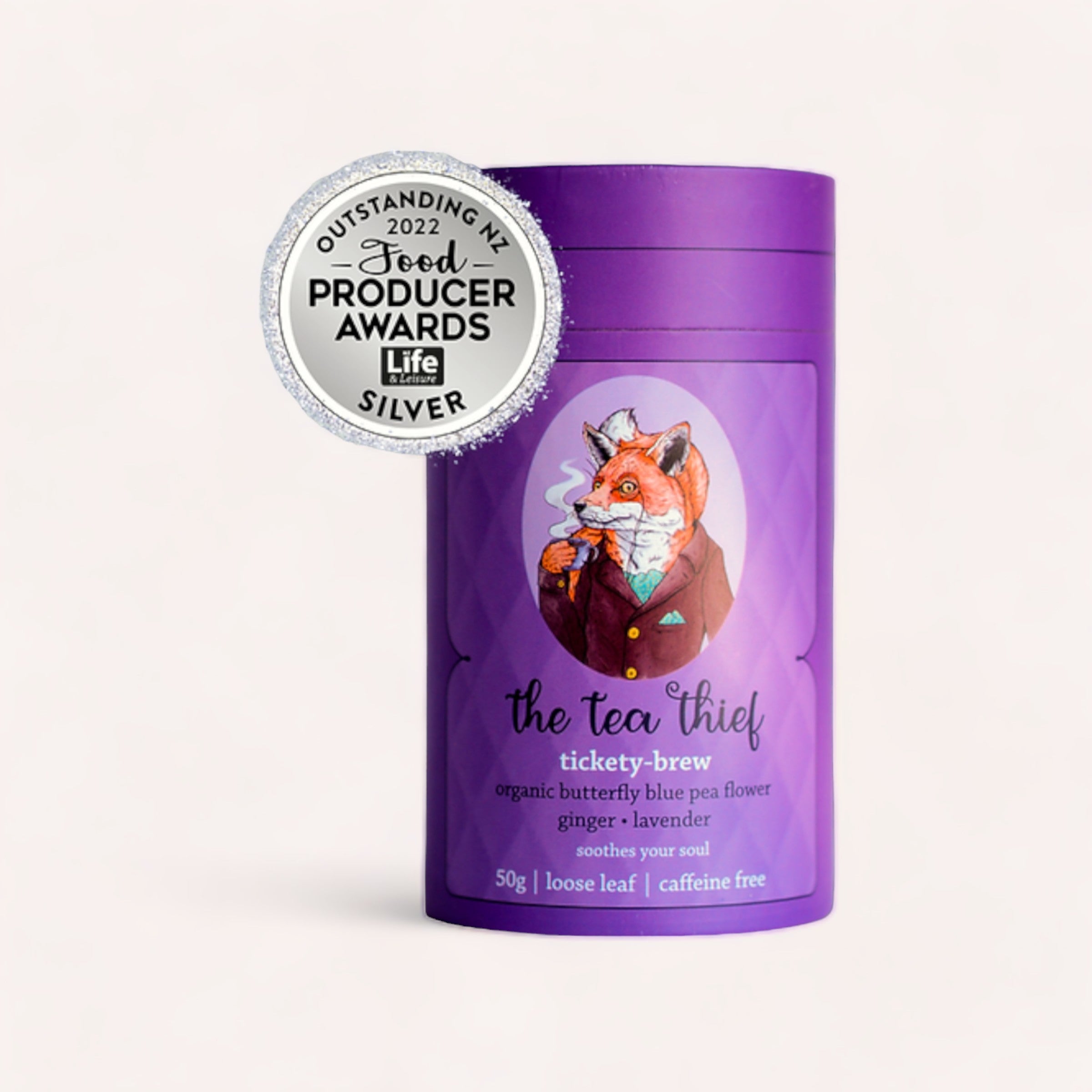 A vibrant purple container of "Tickety Brew 50g by The Tea Thief" organic butterfly blue pea flower ginger-lavender tea, winner of the 2022 Good Producer Awards Silver Life, in a