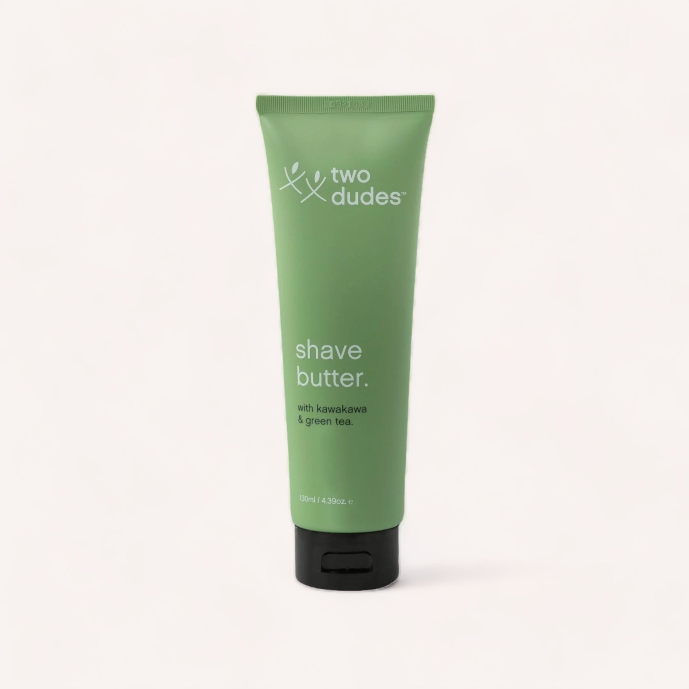A green tube of Two Dudes brand Shave Butter by Two Dudes with kawakawa & green tea, formulated to reduce skin irritation and razor burn, against a clean, white background.