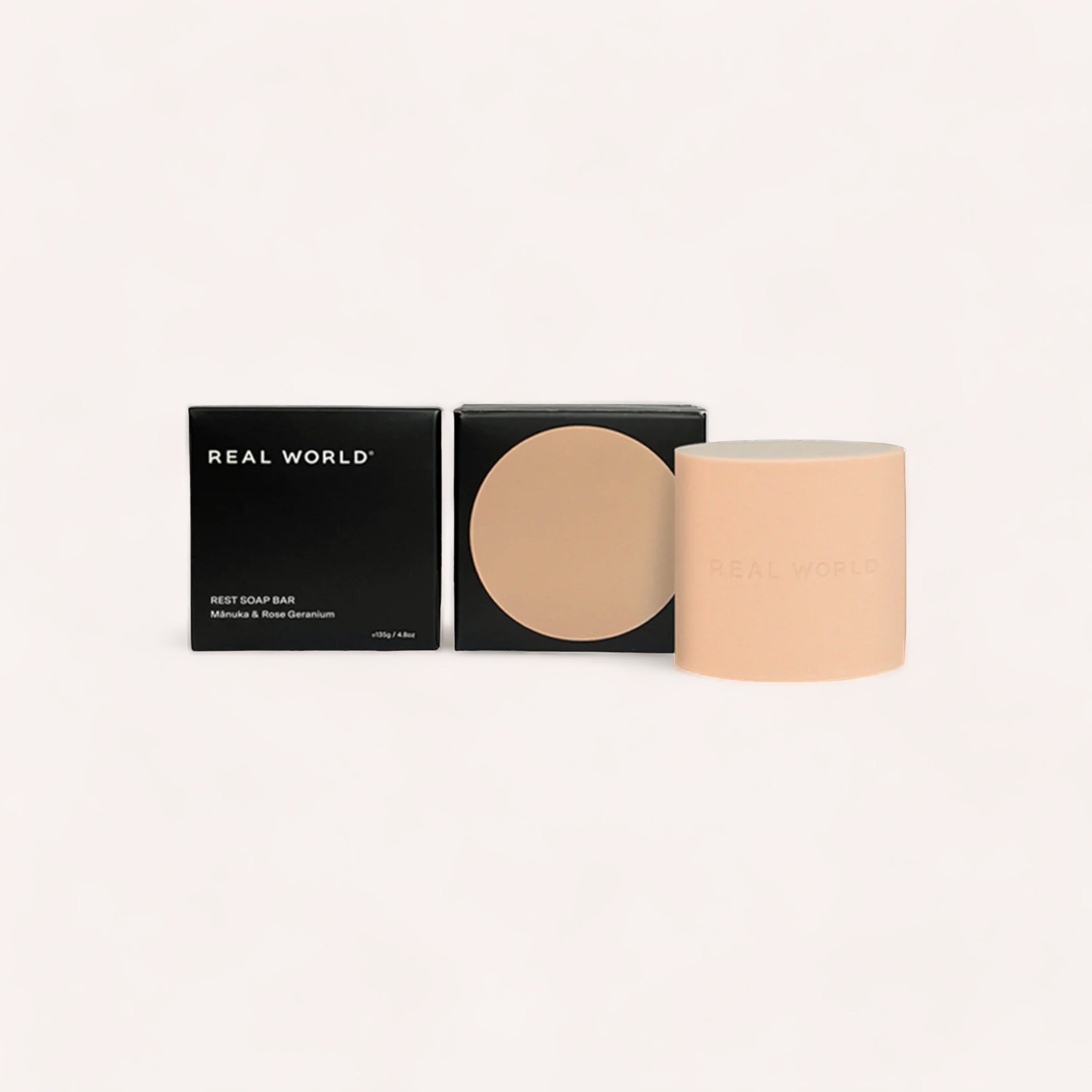 Minimalist skincare products with clean, modern packaging on a neutral background, featuring the healing properties of Manuka & Rose Geranium Soap Bar from Real World.