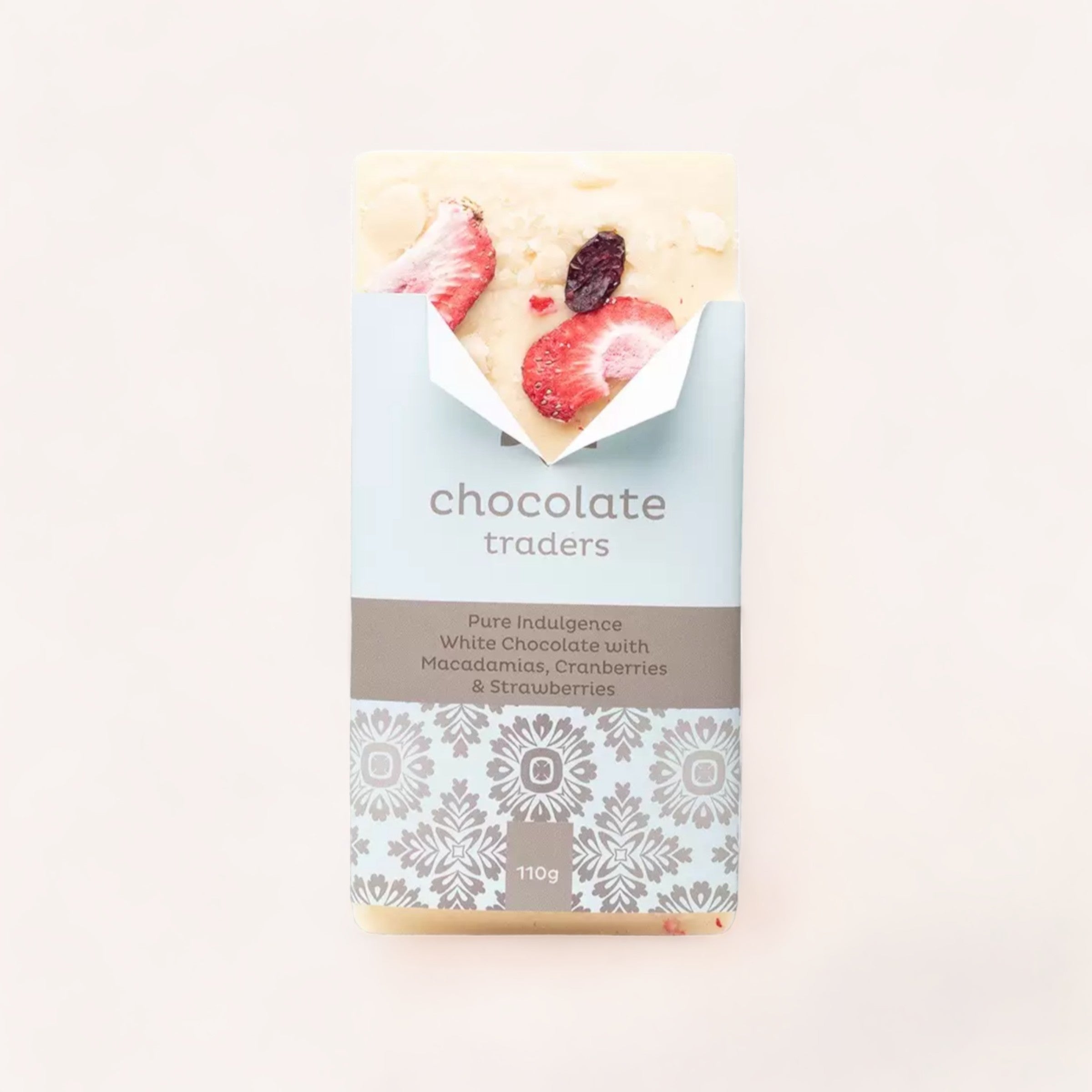 A bar of Pure Indulgence Macadamias, Cranberries & Strawberries white chocolate by Chocolate Traders, elegantly packaged with a sophisticated design, promising a pure indulgence treat. This hand-crafted product of New Zealand.