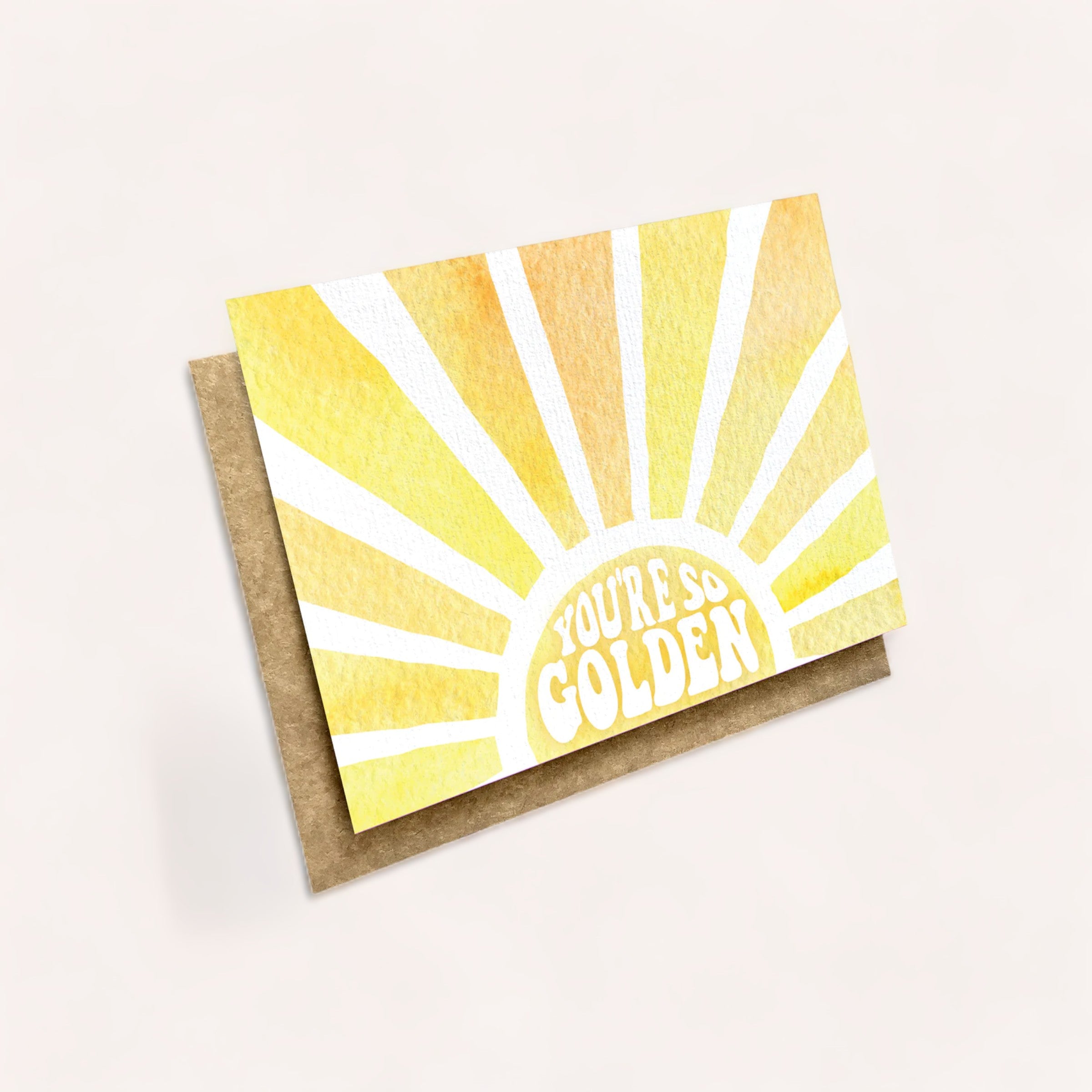 An uplifting You're So Golden Card with a radiant golden sunburst design and the positive affirmation "you're so golden" proudly displayed in the center. This Ink Bomb product of New Zealand is perfect for any occasion.