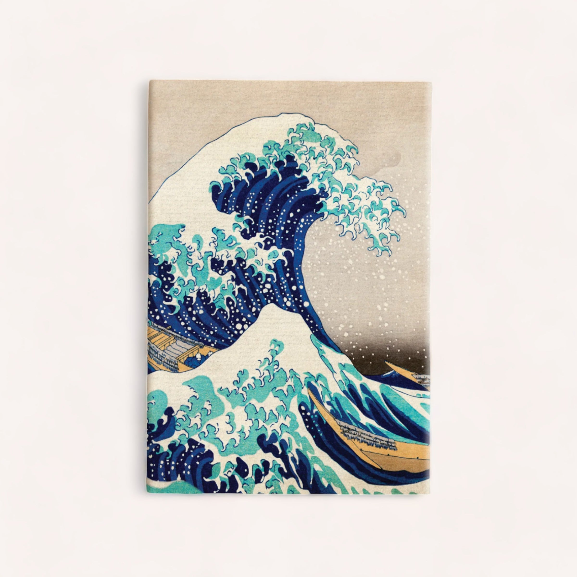 A Waves Notebook featuring "The Great Wave off Kanagawa," the iconic woodblock print by Japanese artist Hokusai, depicting a powerful and frothy ocean wave cresting with Mount Fuji in the background. from Ink Bomb.