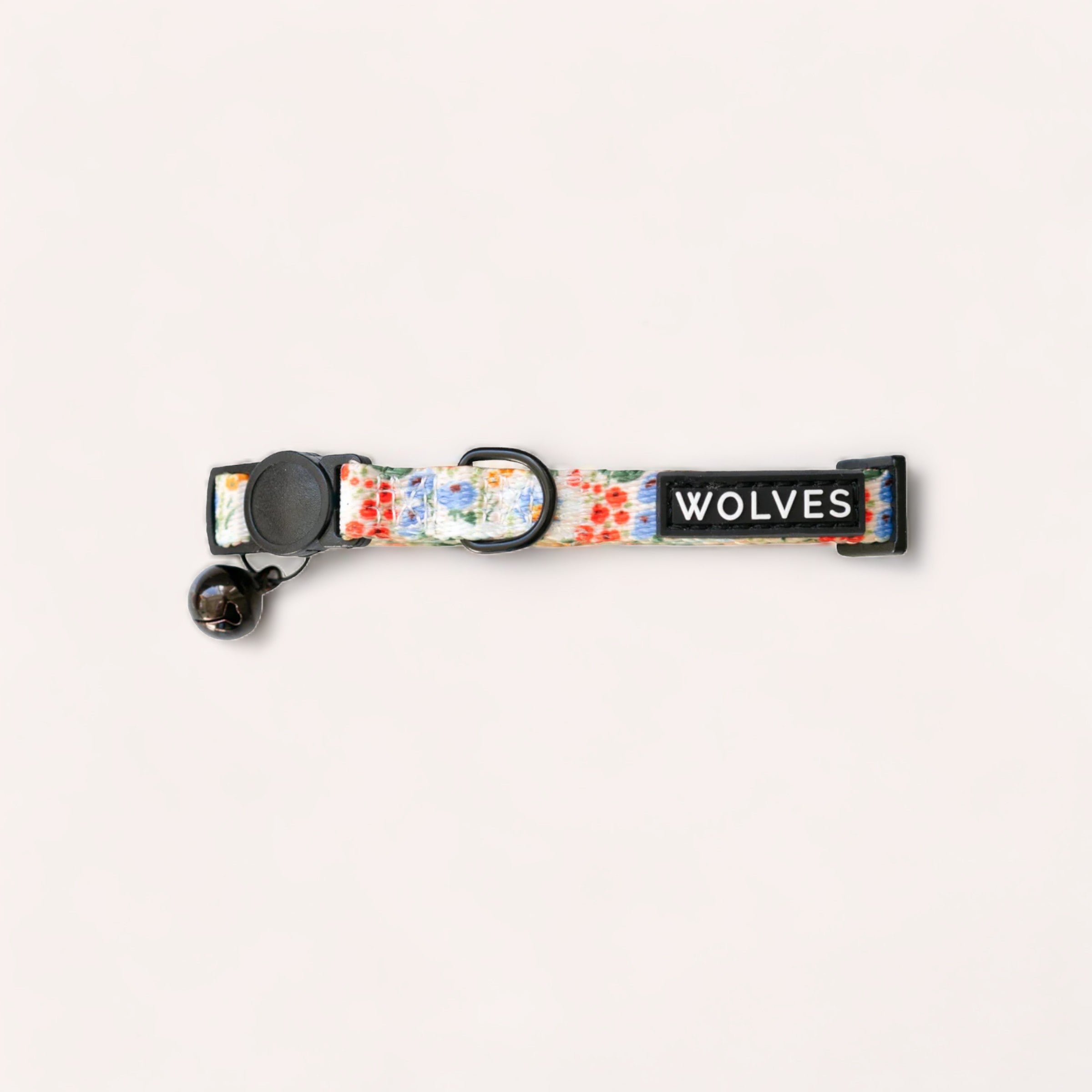 A Posy Cat Collar by Wolves of Wellington with a floral pattern and the word "wolves" printed on it, featuring a breakaway buckle and key ring.
