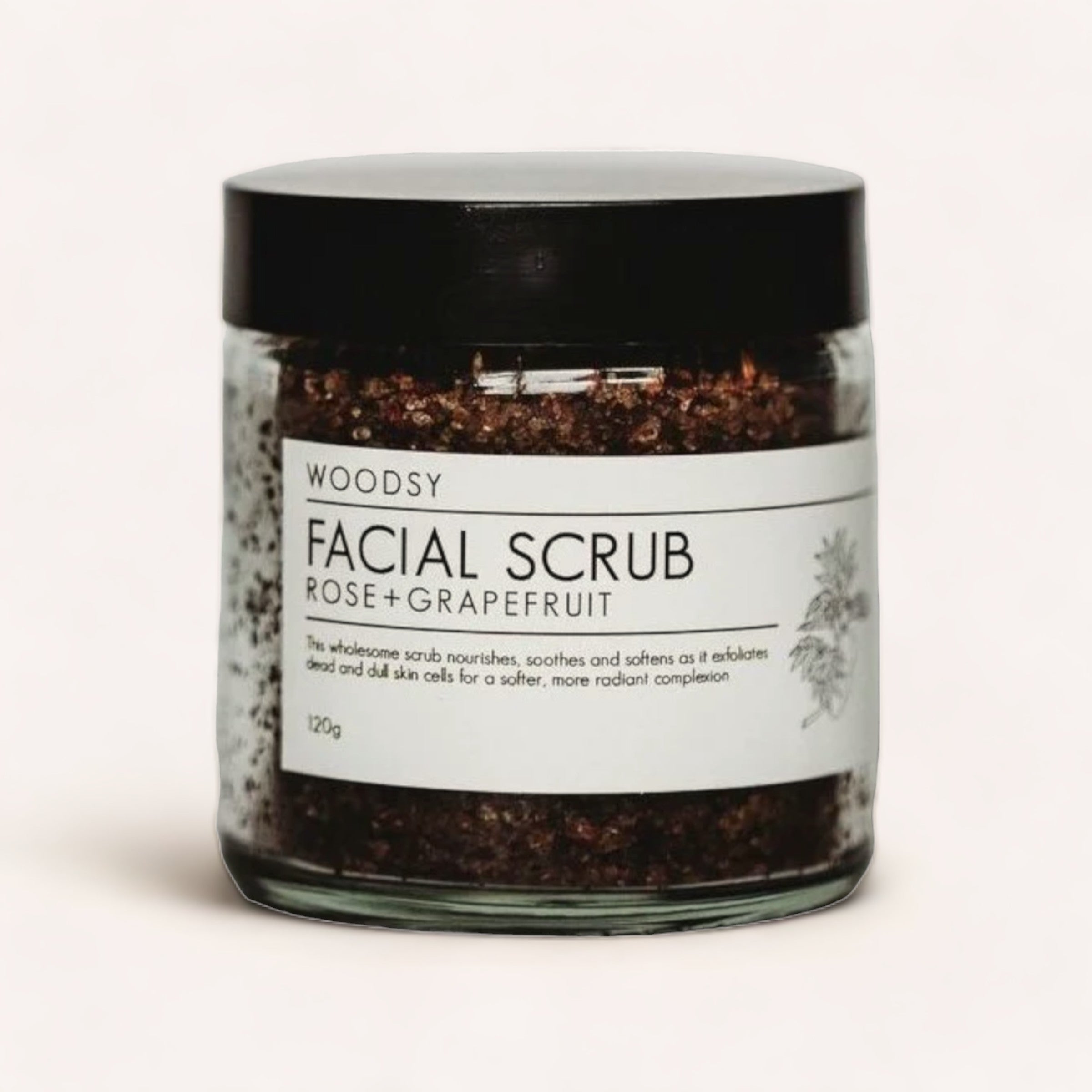 Sentence with replaced product and brand name: A jar of Facial Scrub - Rose & Grapefruit by Woodsy Botanics, intended to nourish, soothe, and soften the skin for a radiant complexion while facilitating the removal of dead skin cells.