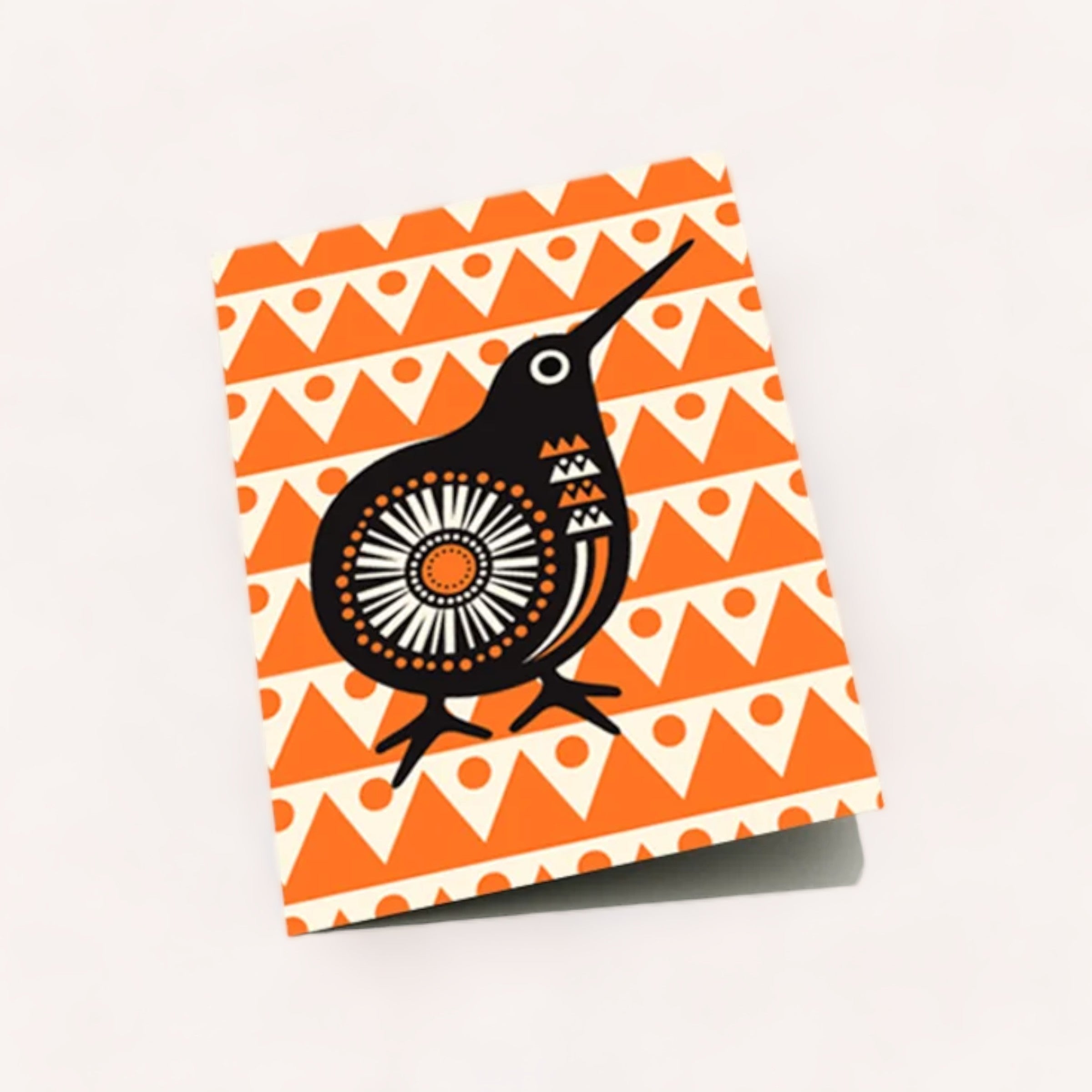 A Retro Kiwi Card with a vibrant geometric pattern and a stylized bird illustration on its cover, set against a light background. Product of New Zealand.