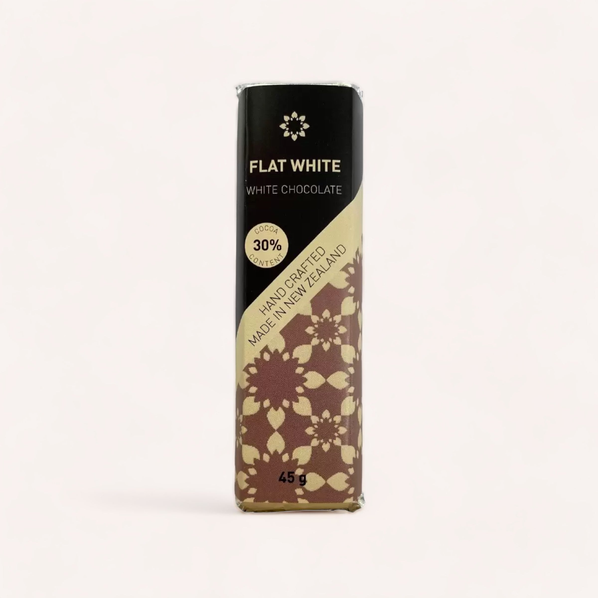 A 45g multibuy Flat White Chocolate bar by Chocolate Traders with 30% cocoa, elegantly wrapped in paper with a floral design, handcrafted in New Zealand.