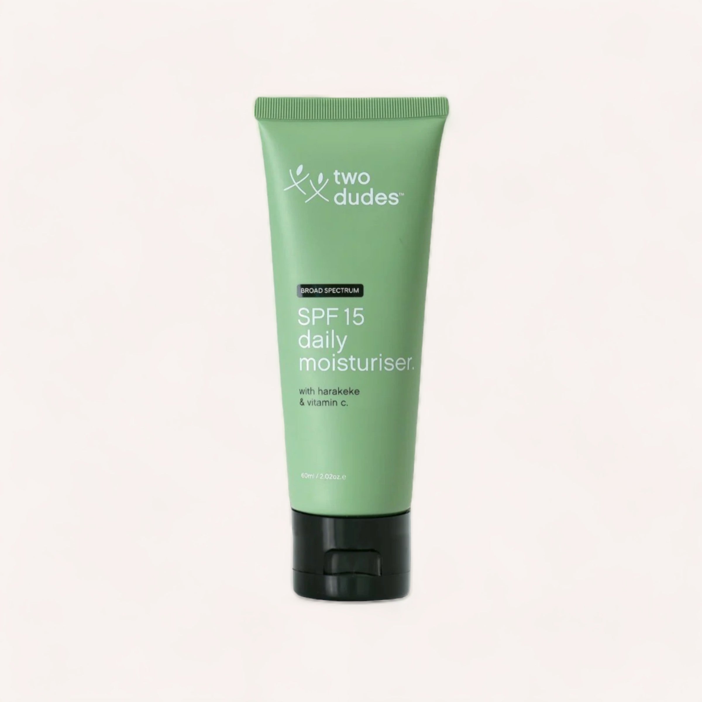 A tube of "Two Dudes" brand SPF15 Daily Moisturiser with harakeke & vitamin c against a neutral background.