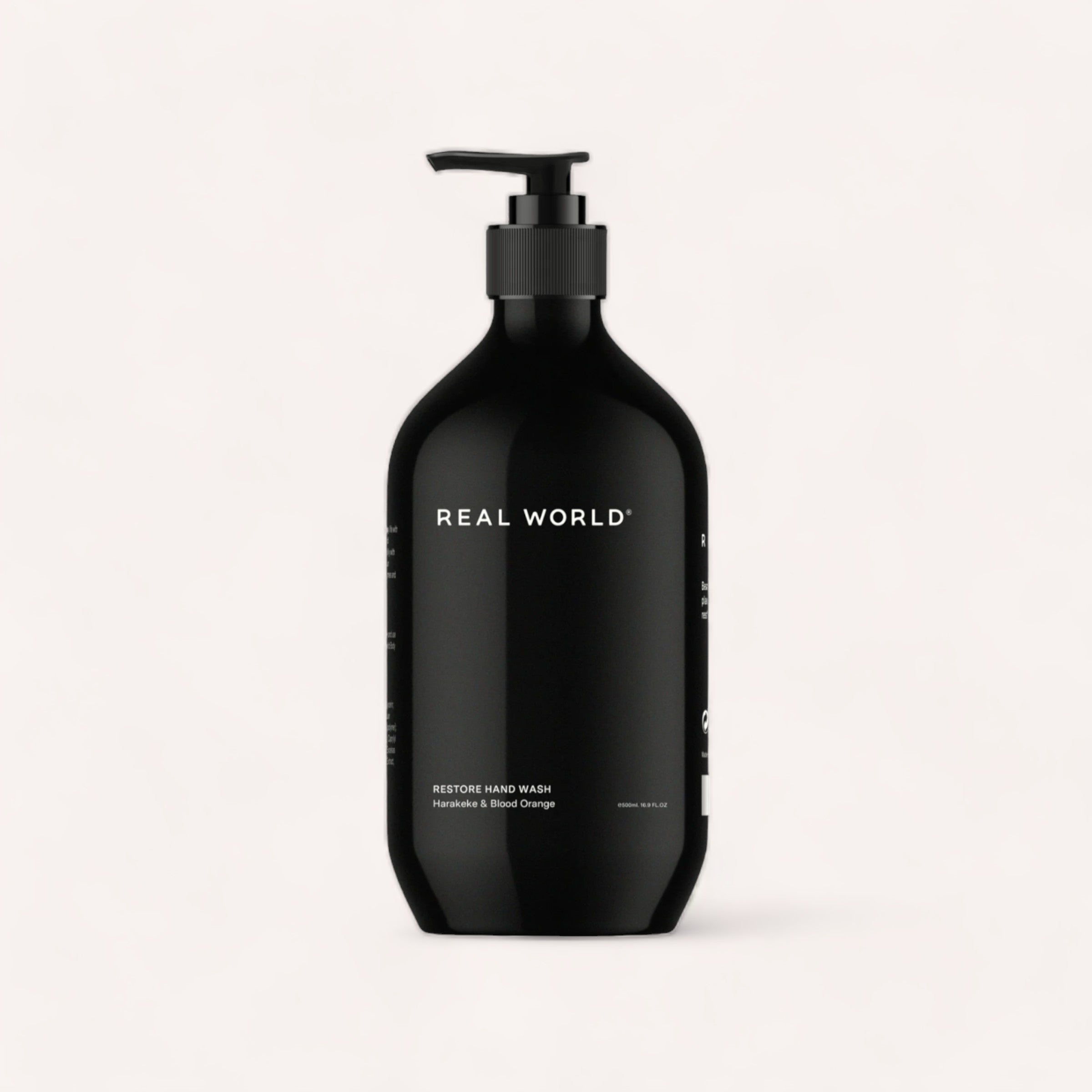 A sleek black bottle of Hand Wash - Harakeke & Blood Orange by Real World, featuring a pump dispenser against a clean, white background.