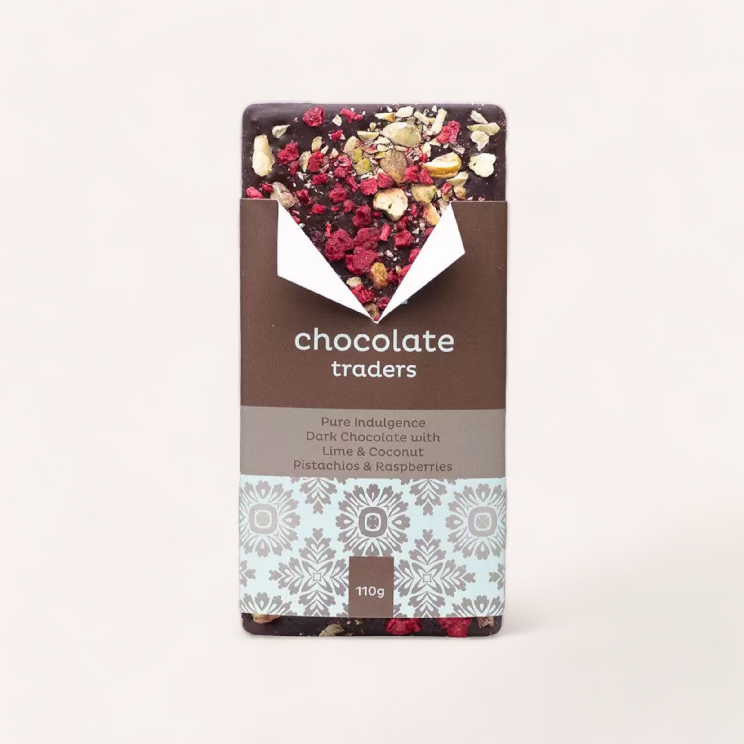 Artisan Pure Indulgence Lime, Coconut, Pistachios & Raspberries dark chocolate bar by Chocolate Traders against a neutral background; a perfect gift from New Zealand.