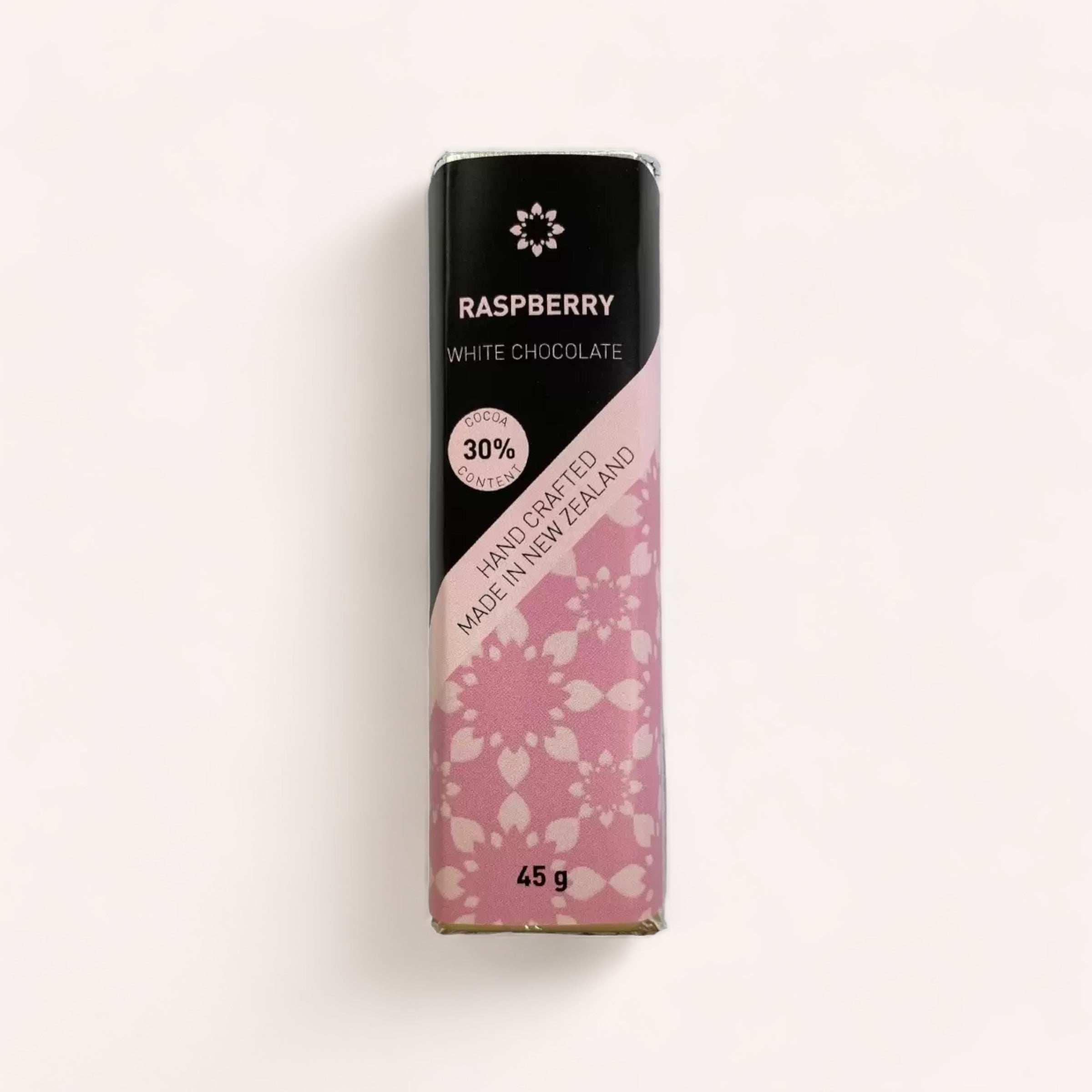 A bar of Raspberry White Chocolate bar with a 30% cocoa content, handcrafted and presented in a package with pink floral patterns, weighing 45 grams. This exquisite Product of New Zealand is by Chocolate Traders.