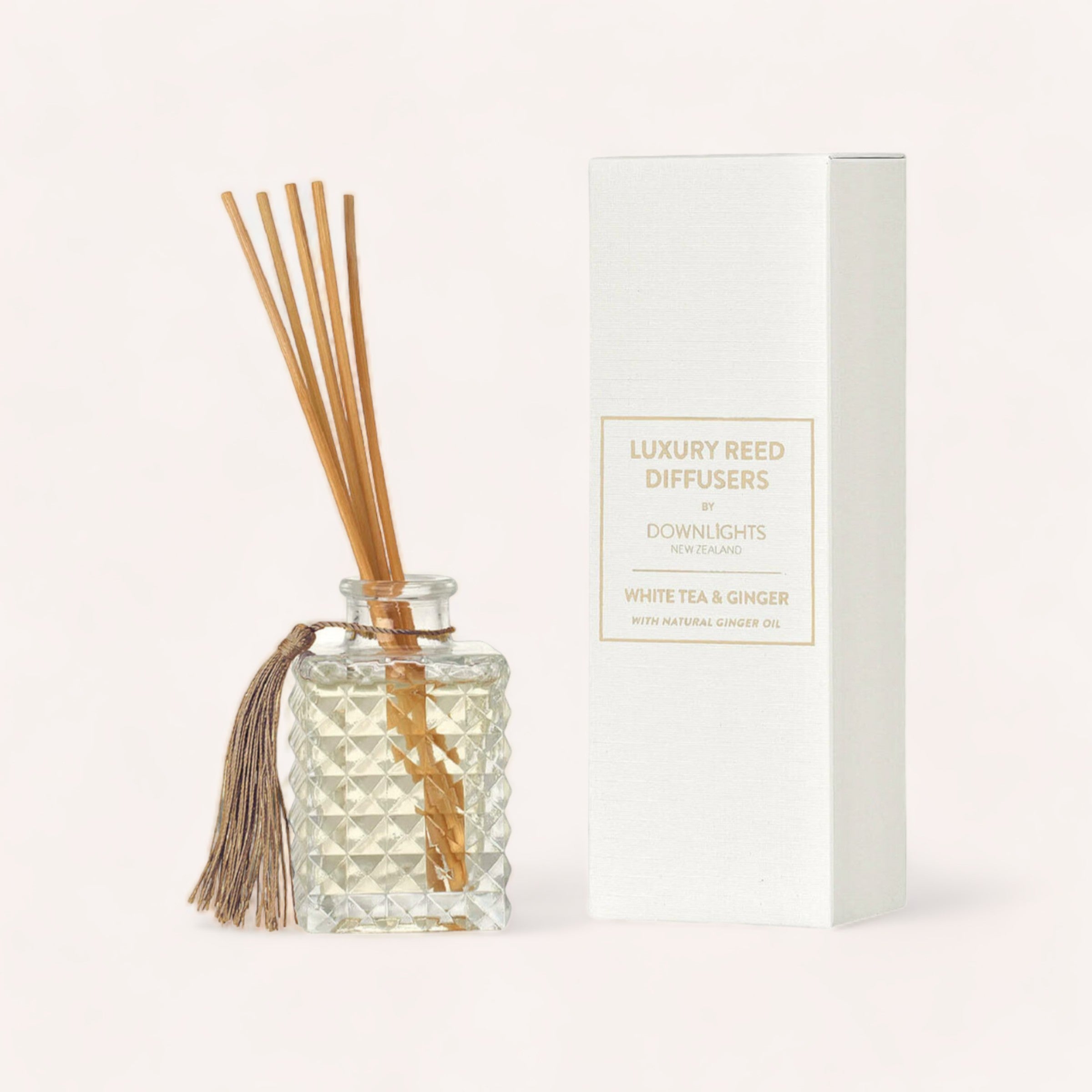 A luxury White Tea & Ginger Diffuser by Downlights, complete with rattan sticks, displayed next to its packaging. Product of New Zealand.