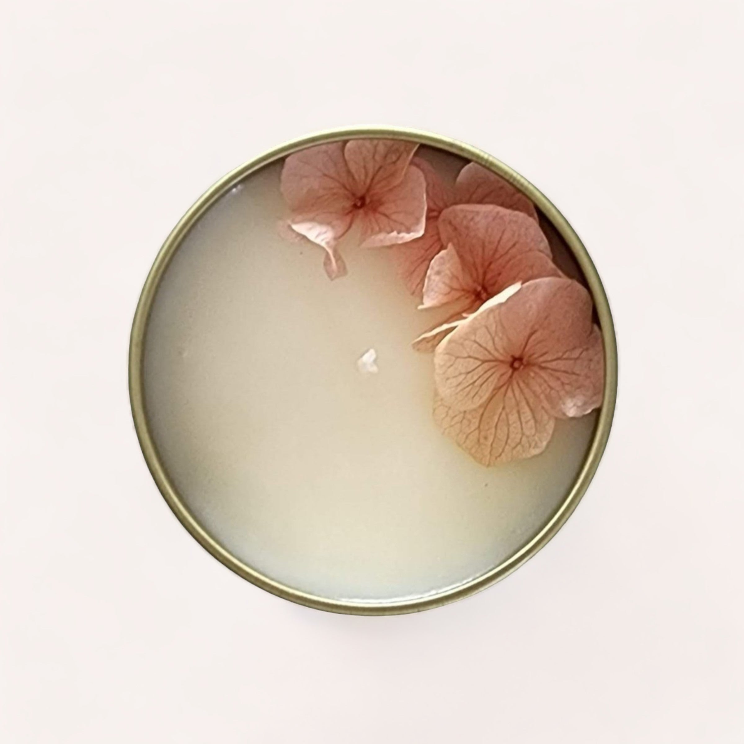 A serene Green Tea + Lemongrass Candle adorned with delicate pink petals against a soft white background, emitting a subtle green tea fragrance by Wix's Lane Co.