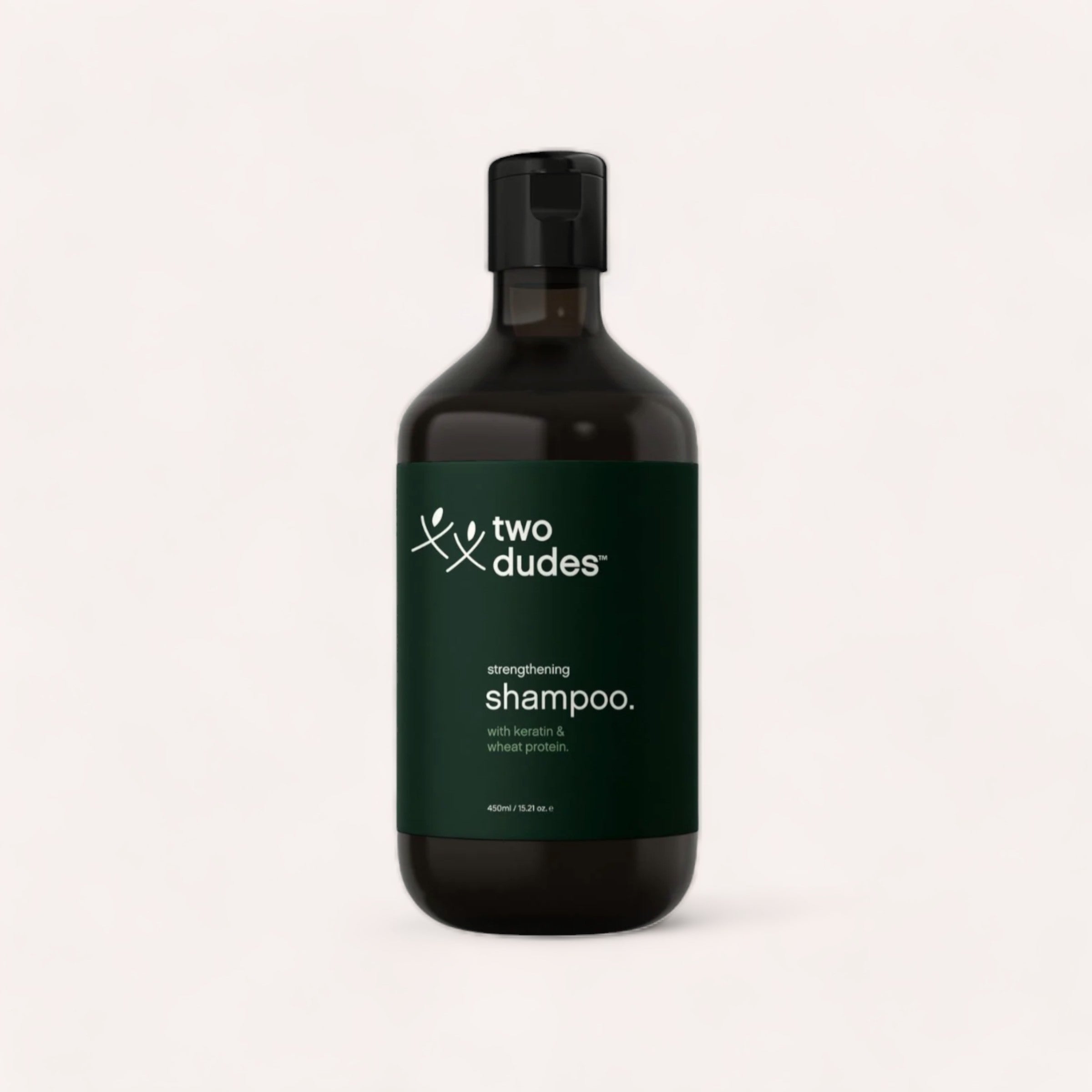 A sleek bottle of Shampoo by Two Dudes hair growth strengthening shampoo with keratin and wheat protein against a neutral background.