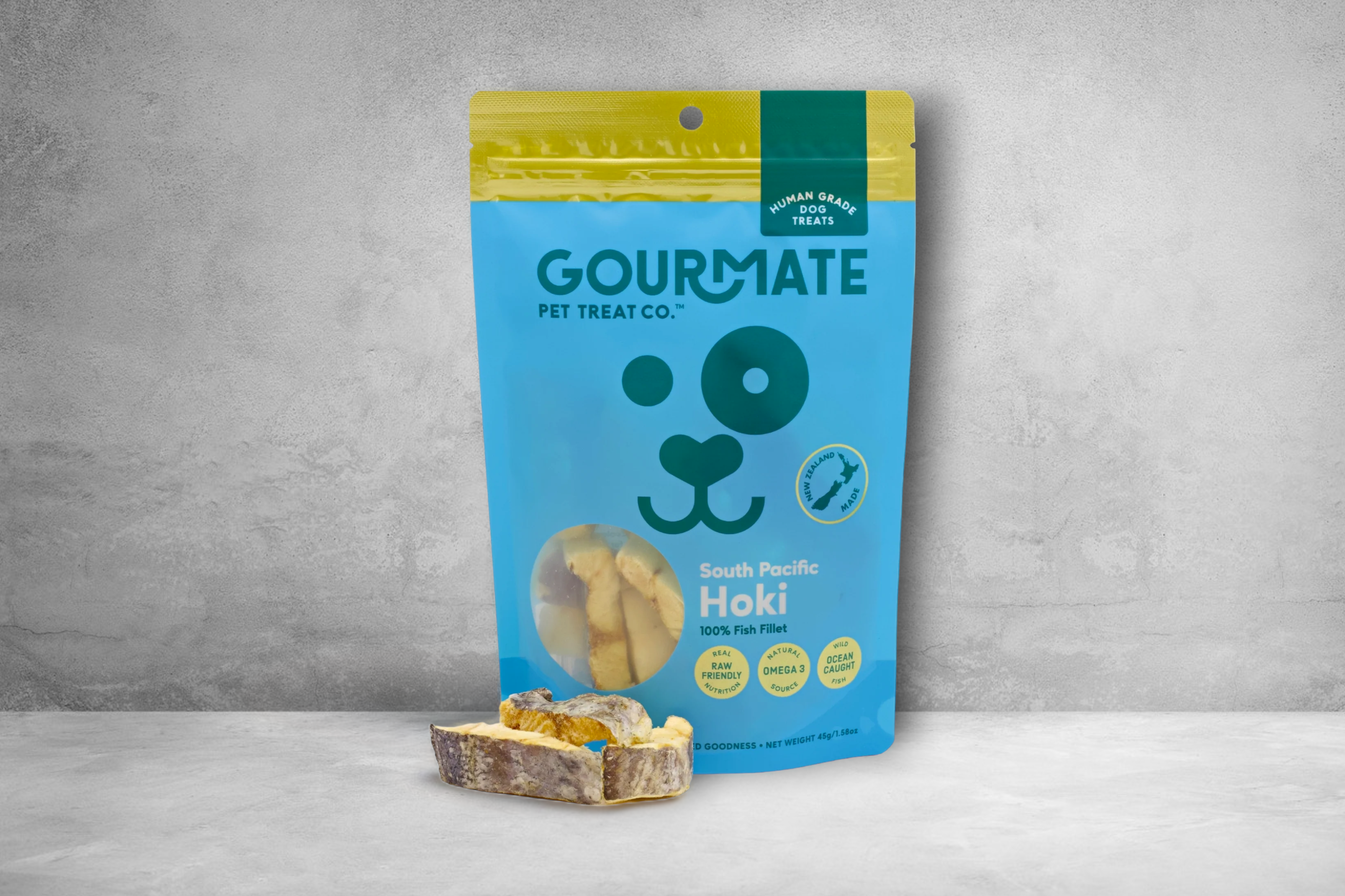 A vibrant package of Gourmate Pet Treat Co. South Pacific Hoki Treats, enriched with omega-3, with a sample of the product displayed in front.