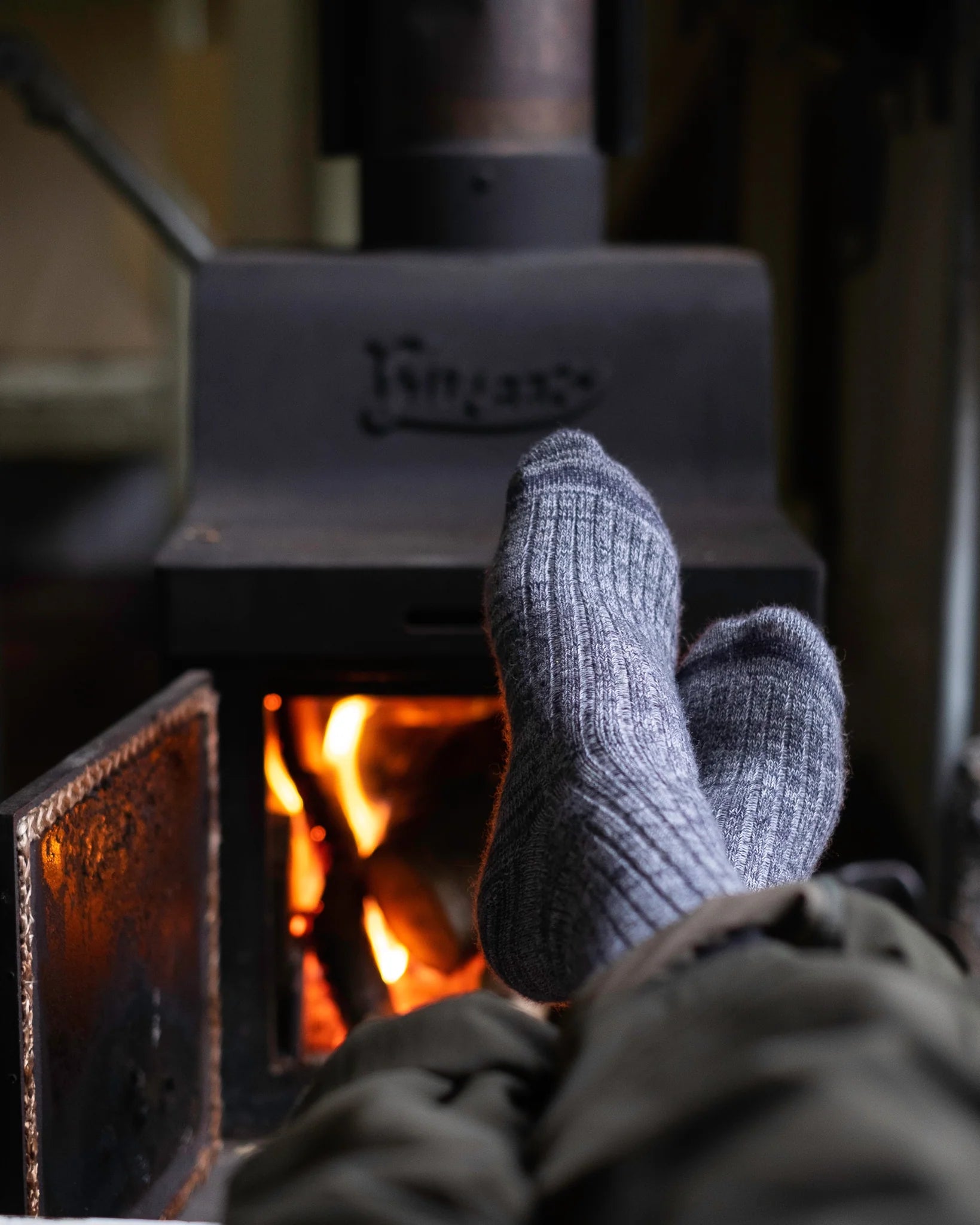 Cozy moments: warming up by the crackling wood stove with toasty, sustainably produced Pretty Fly merino wool socks.