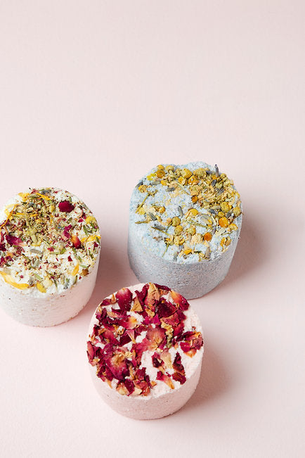 Three Floral Selection Bath Bombs by Botanical Skin Care from New Zealand, decorated with dried flowers on a pale pink background.