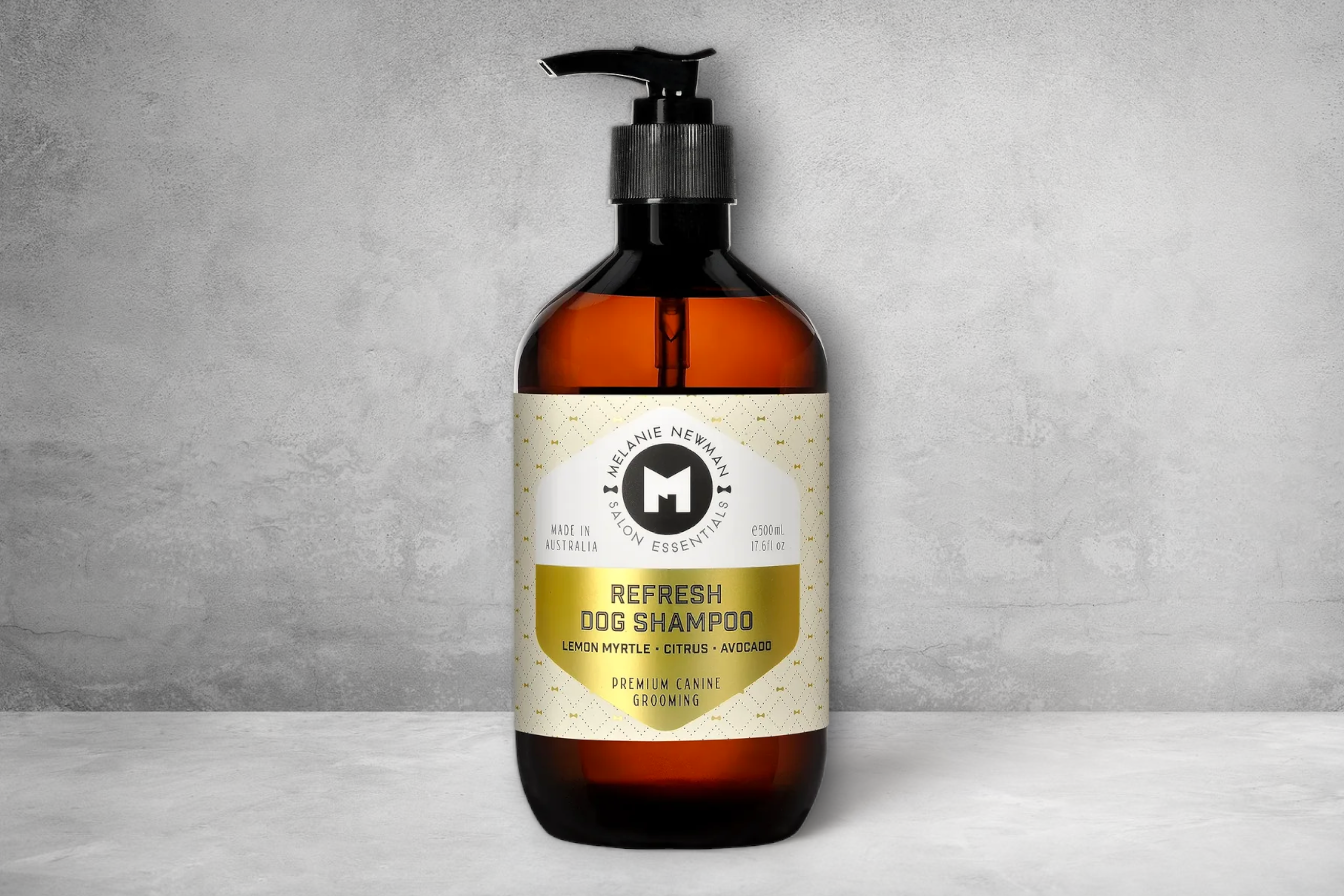 A bottle of "Refresh Dog Shampoo by Melanie Newman" featuring Australian lemon myrtle and avocado oil scents, presented against a simple grey background, emphasizing its premium grooming properties for double-coated breeds.