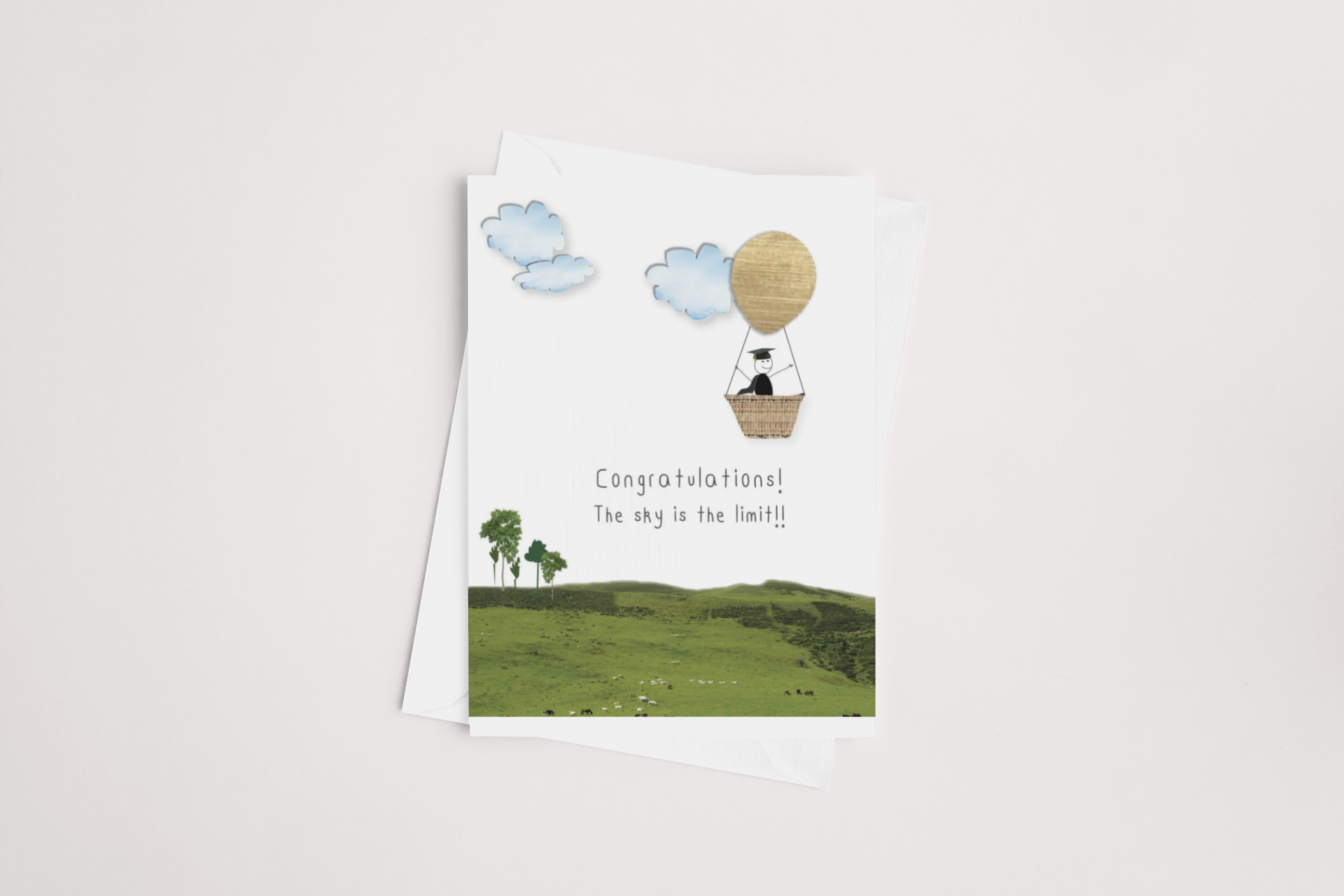 A Kiwi Graduation Card with a pastoral scene and a hot air balloon, featuring the congratulatory phrase "Congratulations! The sky is the limit!!" This multibuy product of icandy New Zealand is perfect for various occasions.