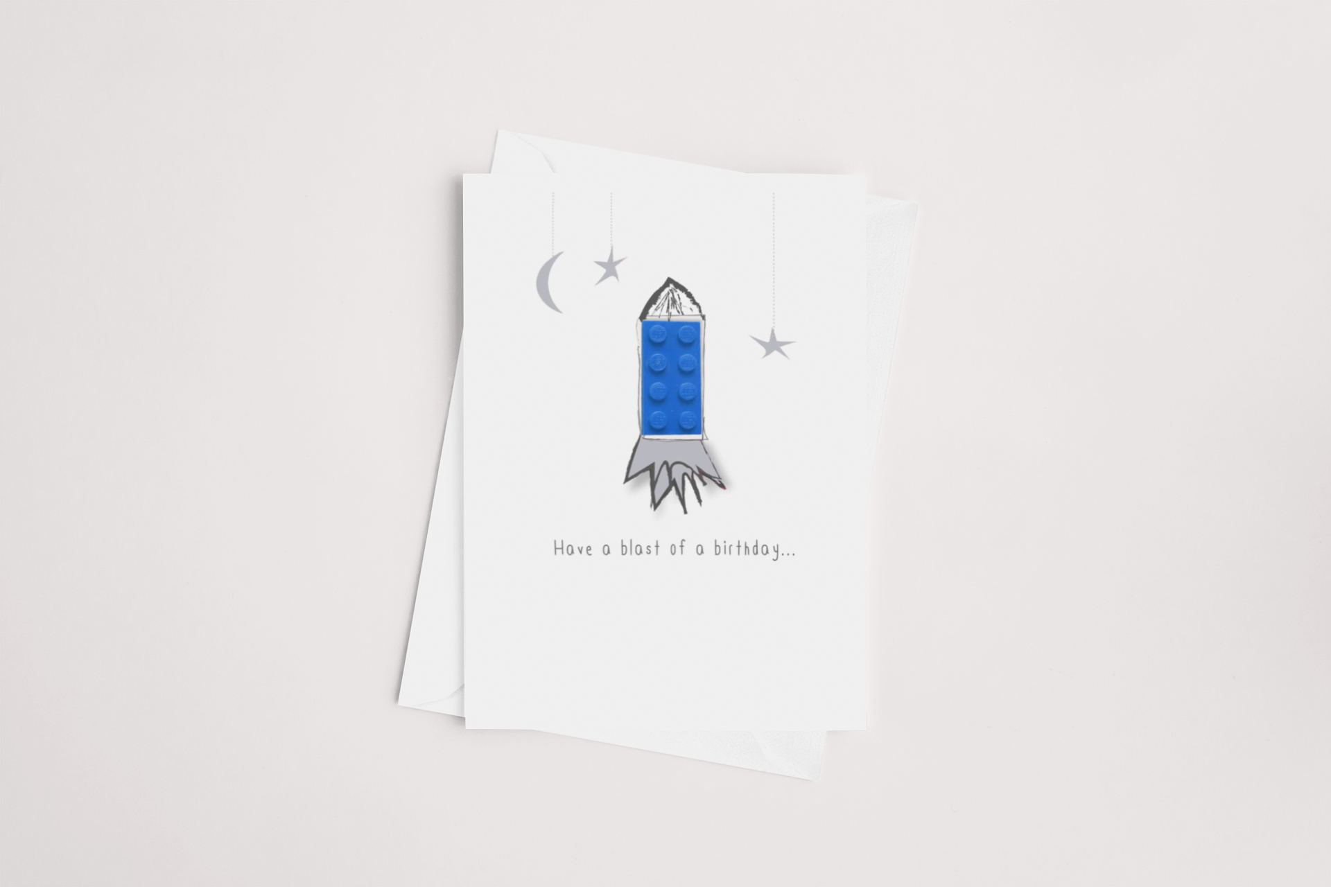 A playful greeting card featuring an illustration of a Lego rocket with the punny message "have a blast of a birthday..." suggesting a fun and high-spirited celebration. Blank inside for your personal message, by icandy.