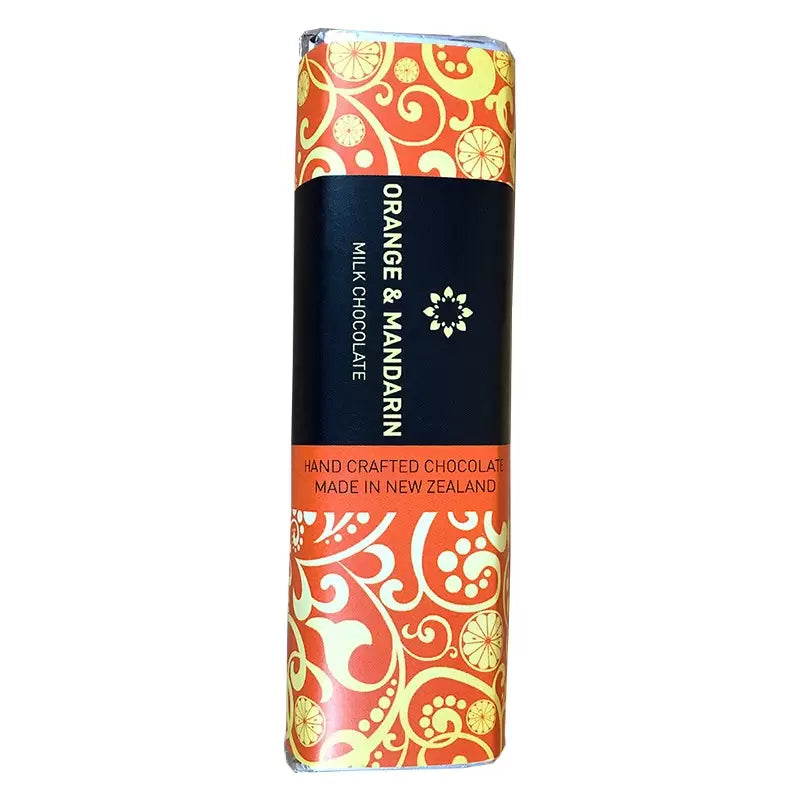 A bar of Celebrate hand-crafted orange & mandarin chocolate made in New Zealand, wrapped in a decorative orange and yellow paper with swirls and citrus fruit designs, paired with a bottle of non-alcoholic from giftbox co.
