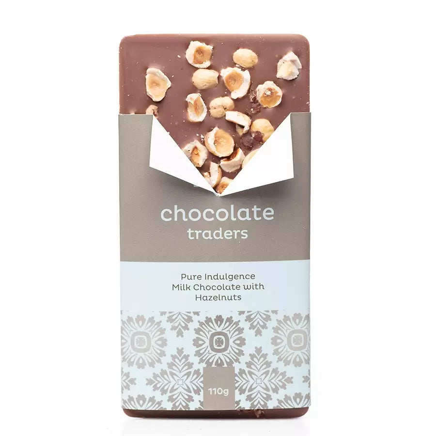 A His milk chocolate bar with hazelnuts on top, partially unwrapped from its grey and white decorative packaging labeled "giftbox co. pure indulgence milk chocolate with hazelnuts, 100g.