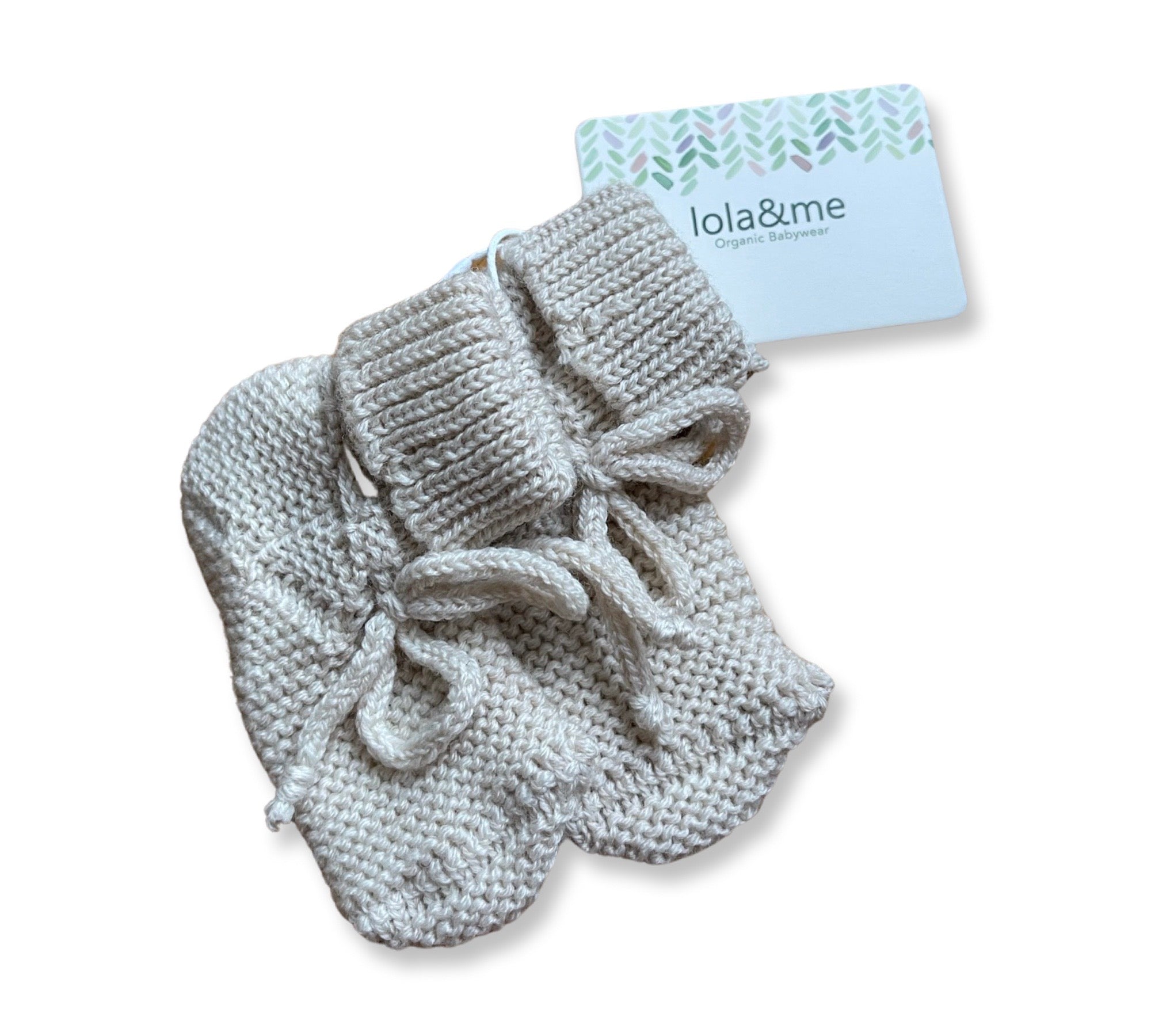 A pair of cozy, merino knit New Arrival baby booties in a neutral color, complete with adorable ribbon ties, displayed next to a brand card that says "giftbox co. organic babywear".