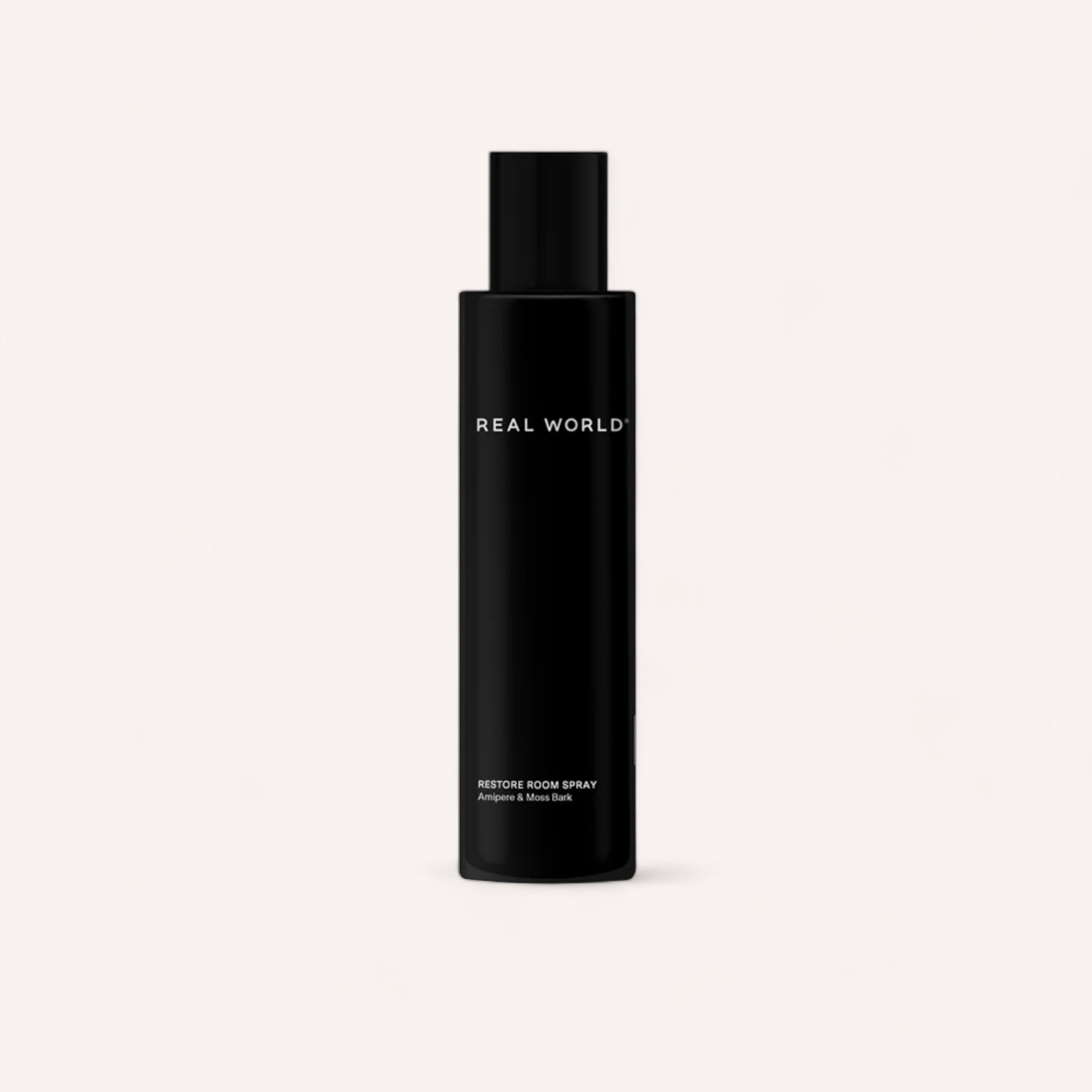 A sleek black bottle with white text labeled "Amipere & Moss Bark Room Spray" fragrance, a Product of New Zealand, against a plain white background by Real World.