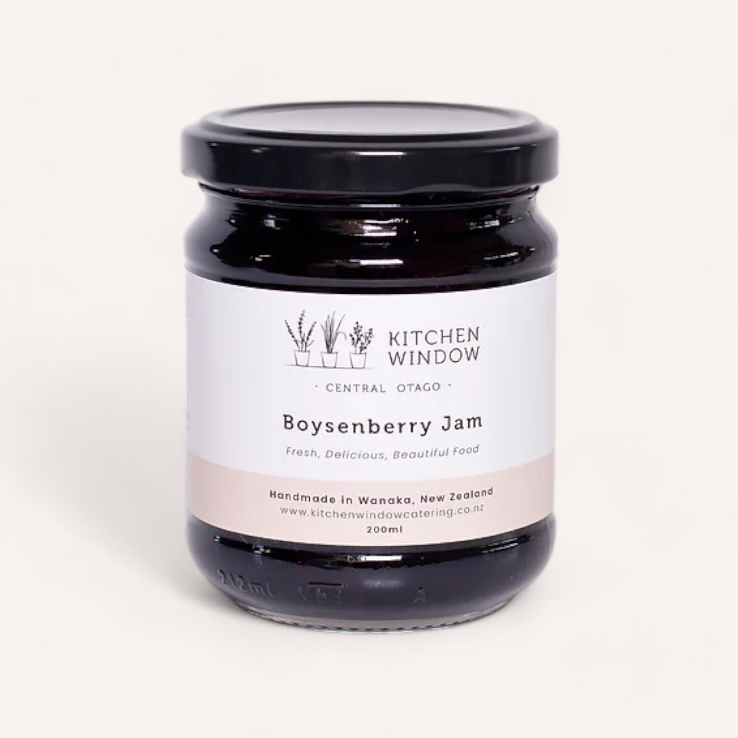 A jar of Boysenberry Jam by Kitchen Window is showcased against a simple backdrop. Its label features elegant black text that states "Kitchen Window, Central Otago" and "Boysenberry Jam: Fresh, Delicious, Beautiful Food." This 200ml jar is a handcrafted treasure from Wanaka, New Zealand, and it proudly displays its NZ Artisan Awards recognition.