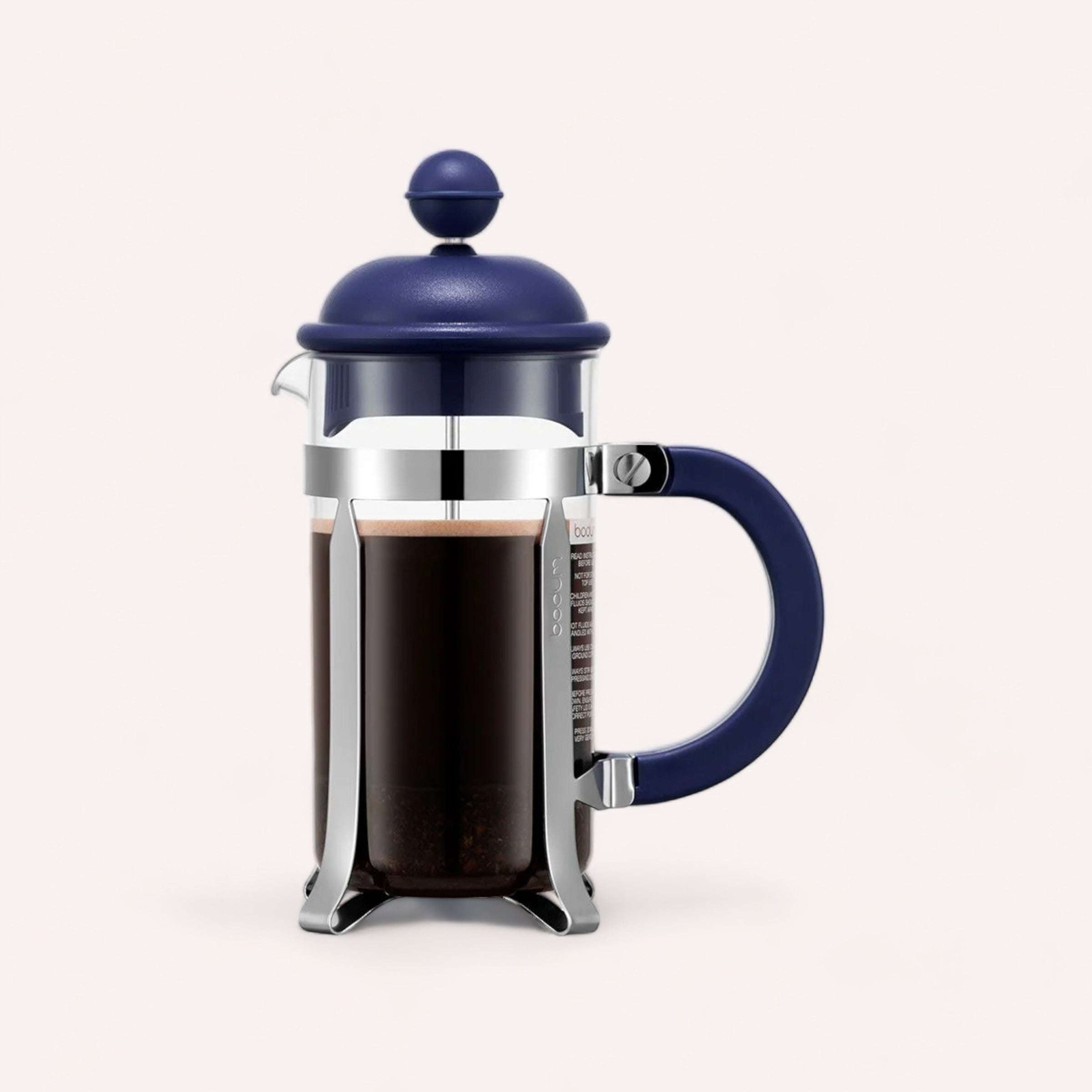 A sleek french press with freshly brewed giftbox co. Coffee, featuring a deep blue lid and handle, against a neutral background.