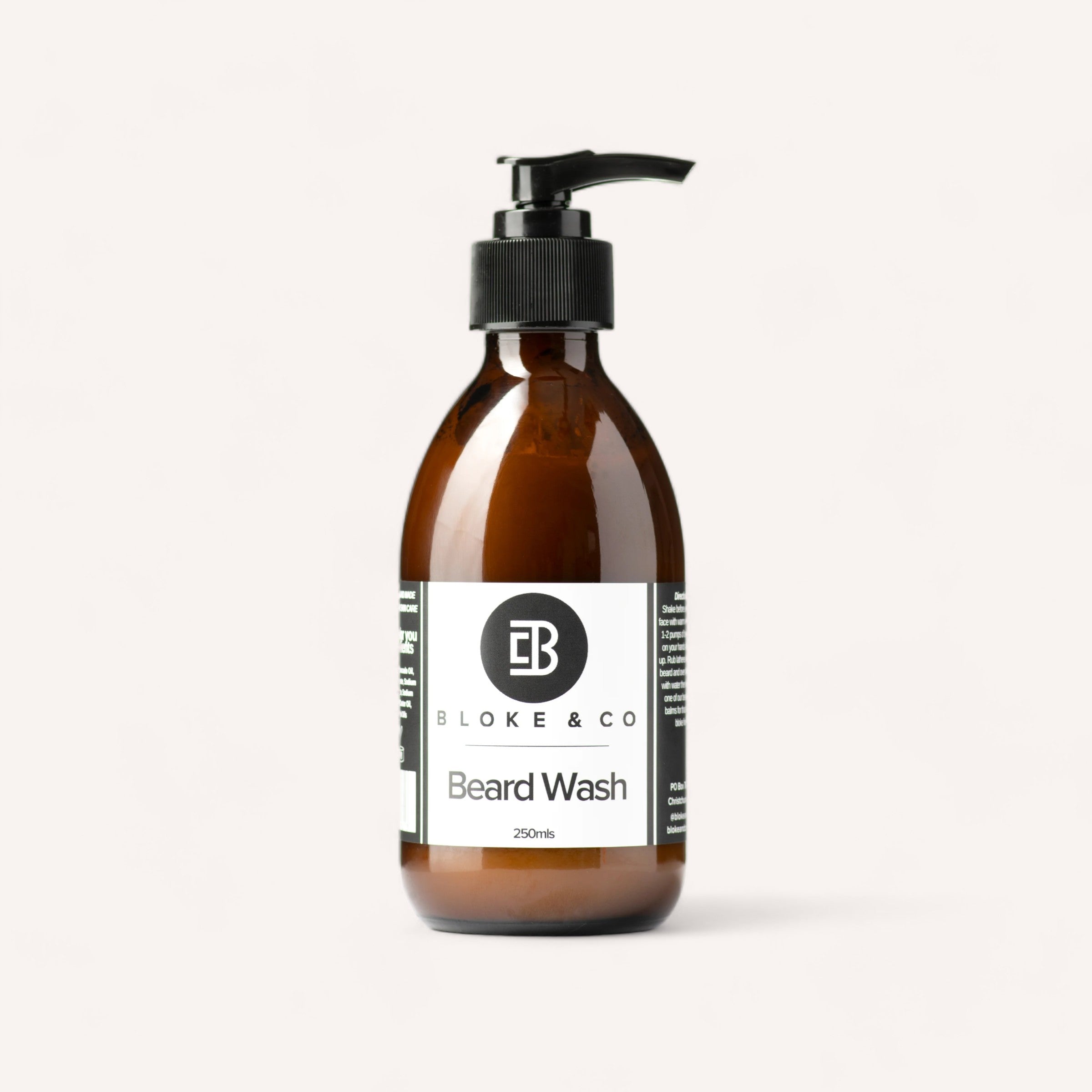Amber glass bottle of Beard Wash by Bloke & Co with a pump dispenser, isolated on a white background.