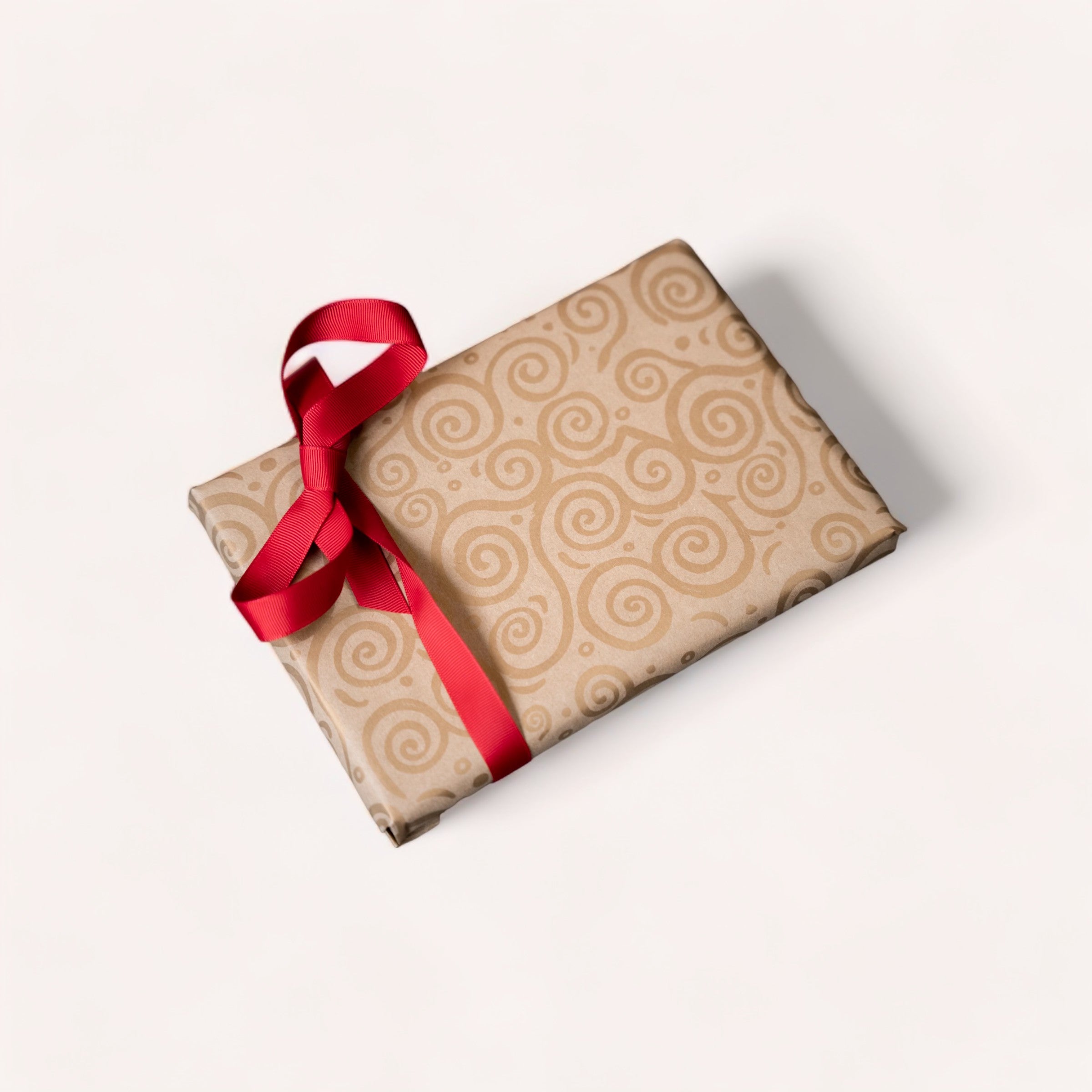 A neatly wrapped gift with a red ribbon, using premium 65gsm giftbox co. paper, against a clean white background.