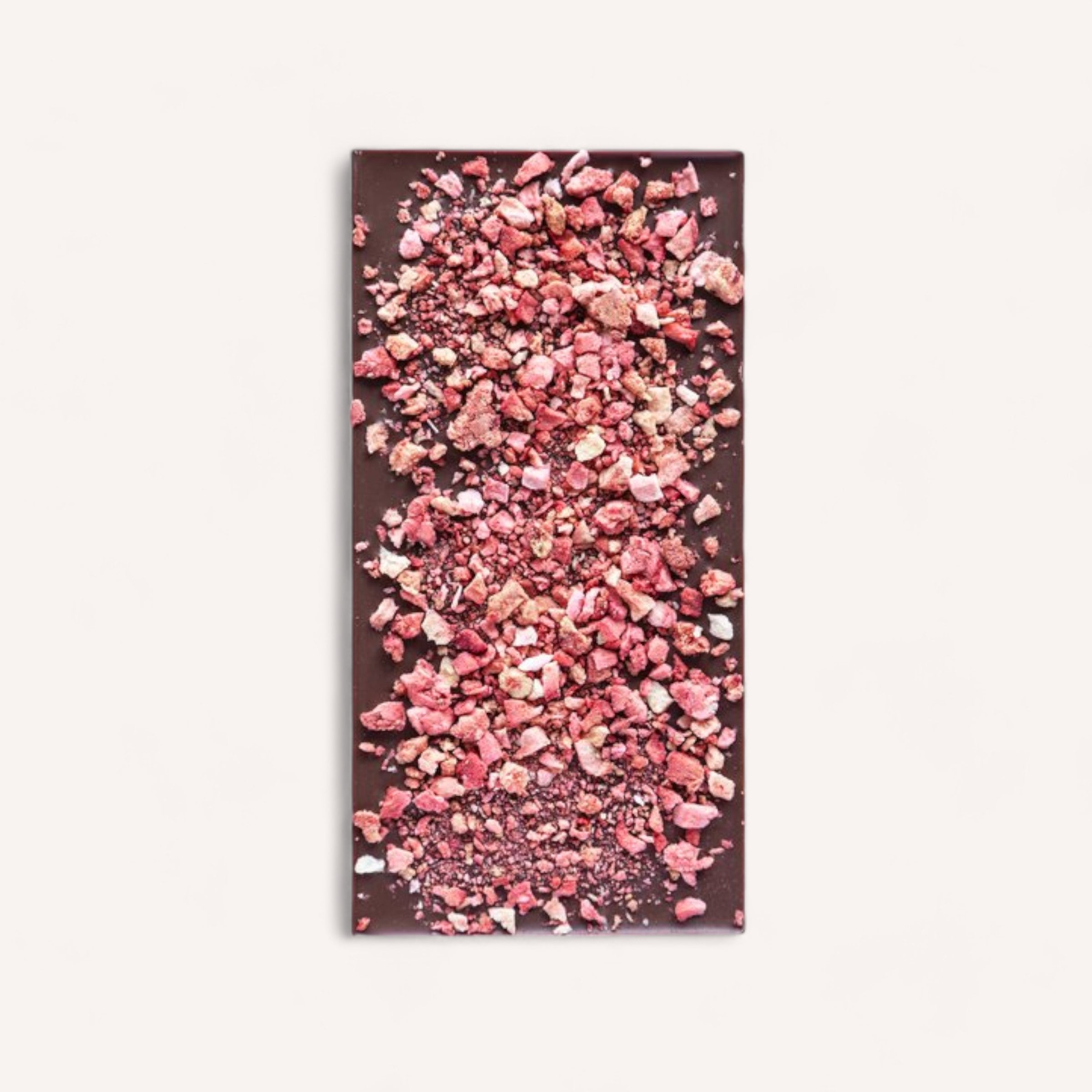 A luxurious Berry Milk Chocolate bar made from Tanzanian cacao, topped with a generous sprinkle of crushed New Zealand strawberries on a clean white background by Shirl & Moss.