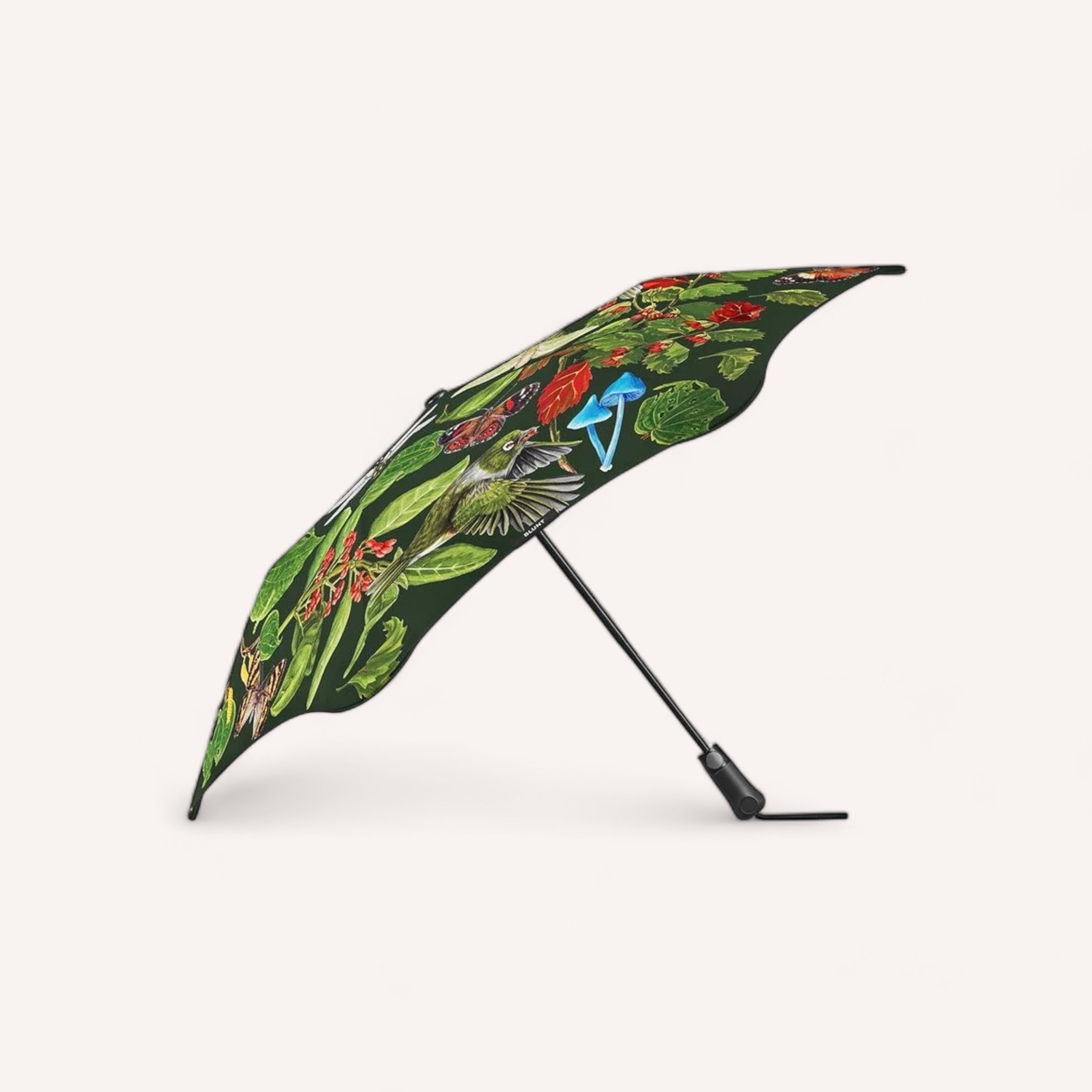 A BLUNT Metro Umbrella Forest & Bird - Limited Edition with a tropical bird and floral design, standing open on a white background.