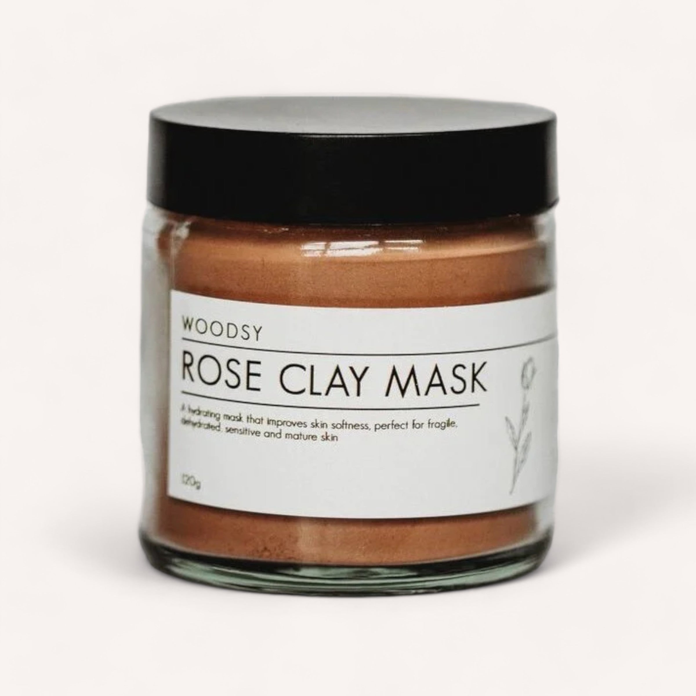 A jar of Rose Clay Mask by Woodsy Botanics for hydrating and soothing, suitable for fragile, sensitive, and mature skin.