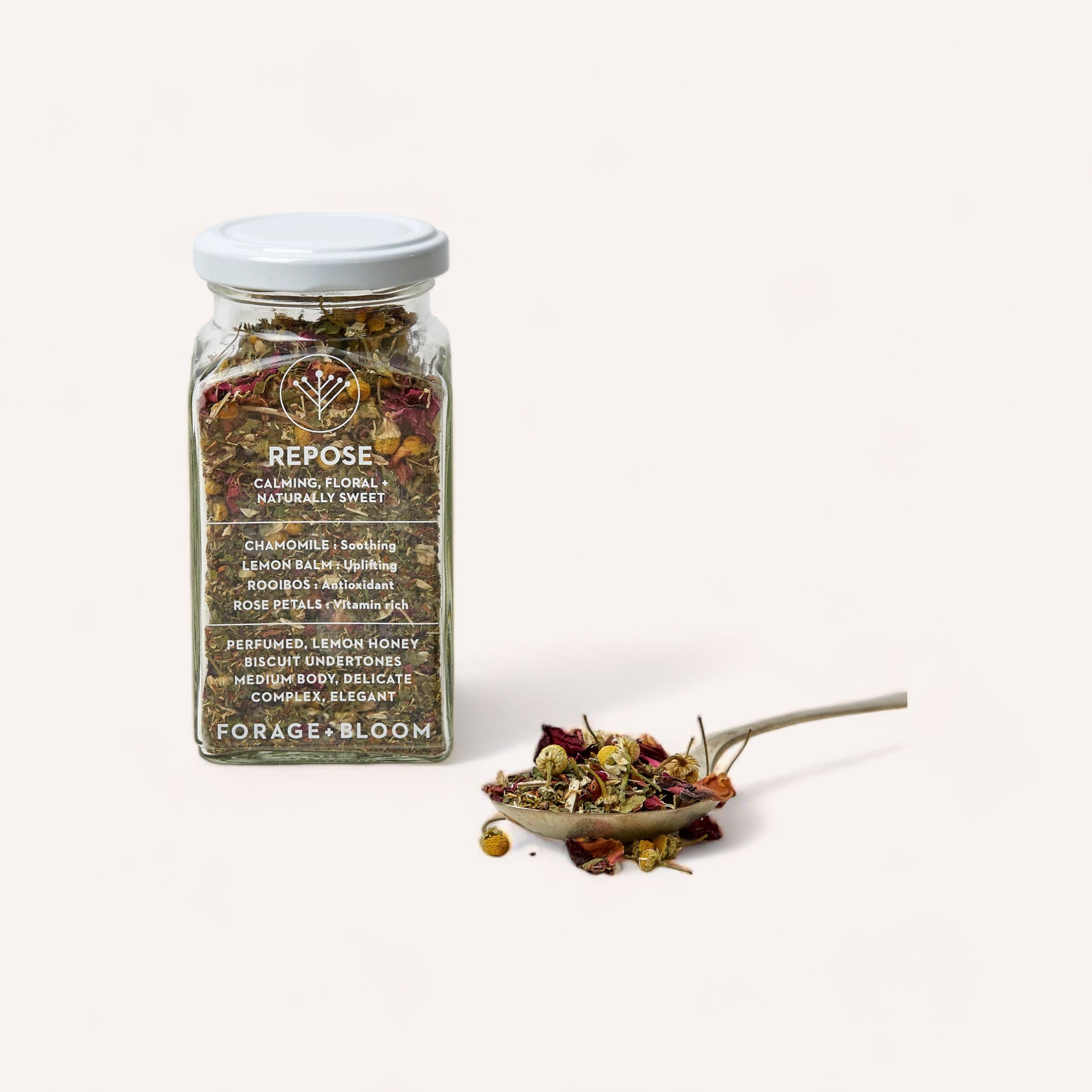 A jar of Repose Tea by Forage + Bloom, with loose tea ingredients artistically scattered in front, symbolizing relaxation and natural wellness.
