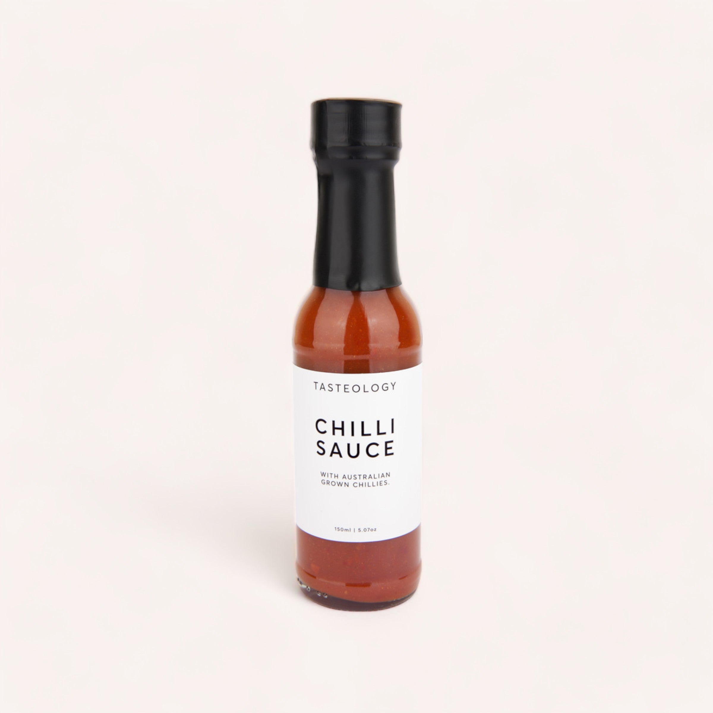 A bottle of Chilli Sauce by Tasteology with Australian grown chillies, ideal for BBQ meats, elegantly presented against a clean white background.