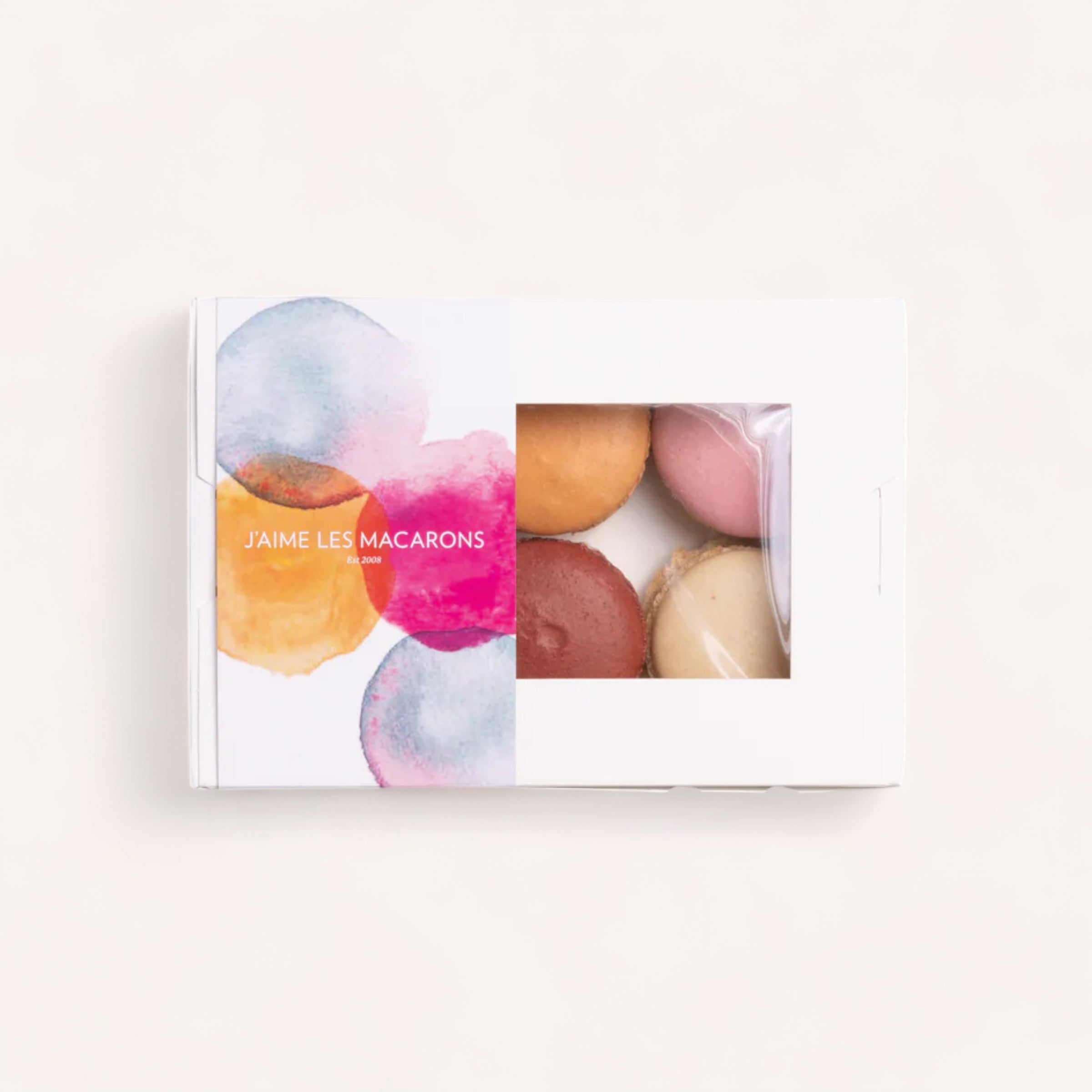 A box of colorful, handmade macarons by J'aime les Macarons with a watercolor design and the phrase "j'aime les macarons" on the cover, suggesting a love for these delicate French pastries.