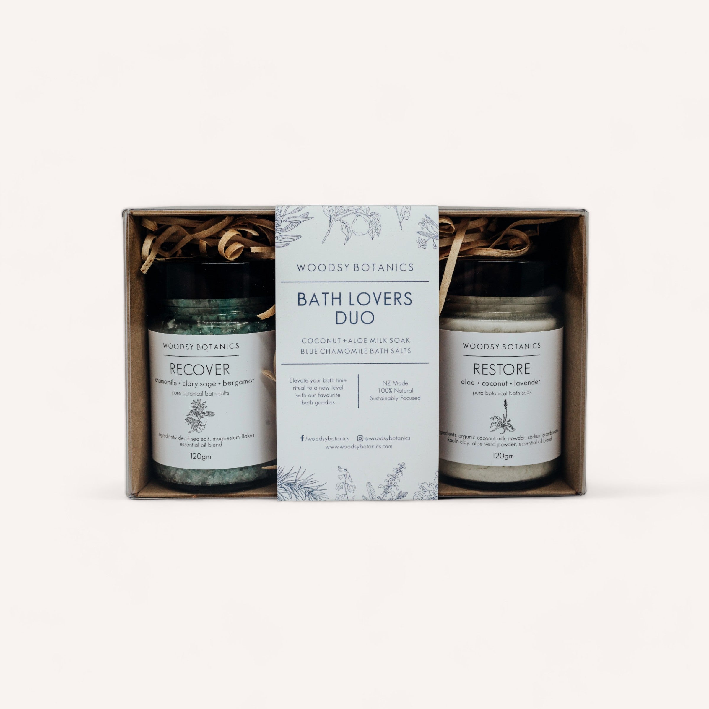 An elegant Bath Lovers gift set containing two jars of woodsy botanics bath salts, with "Recover Salts" and "Restore Soak" blends, presented in a tidy box with a descriptive insert by Woodsy Botanics.
