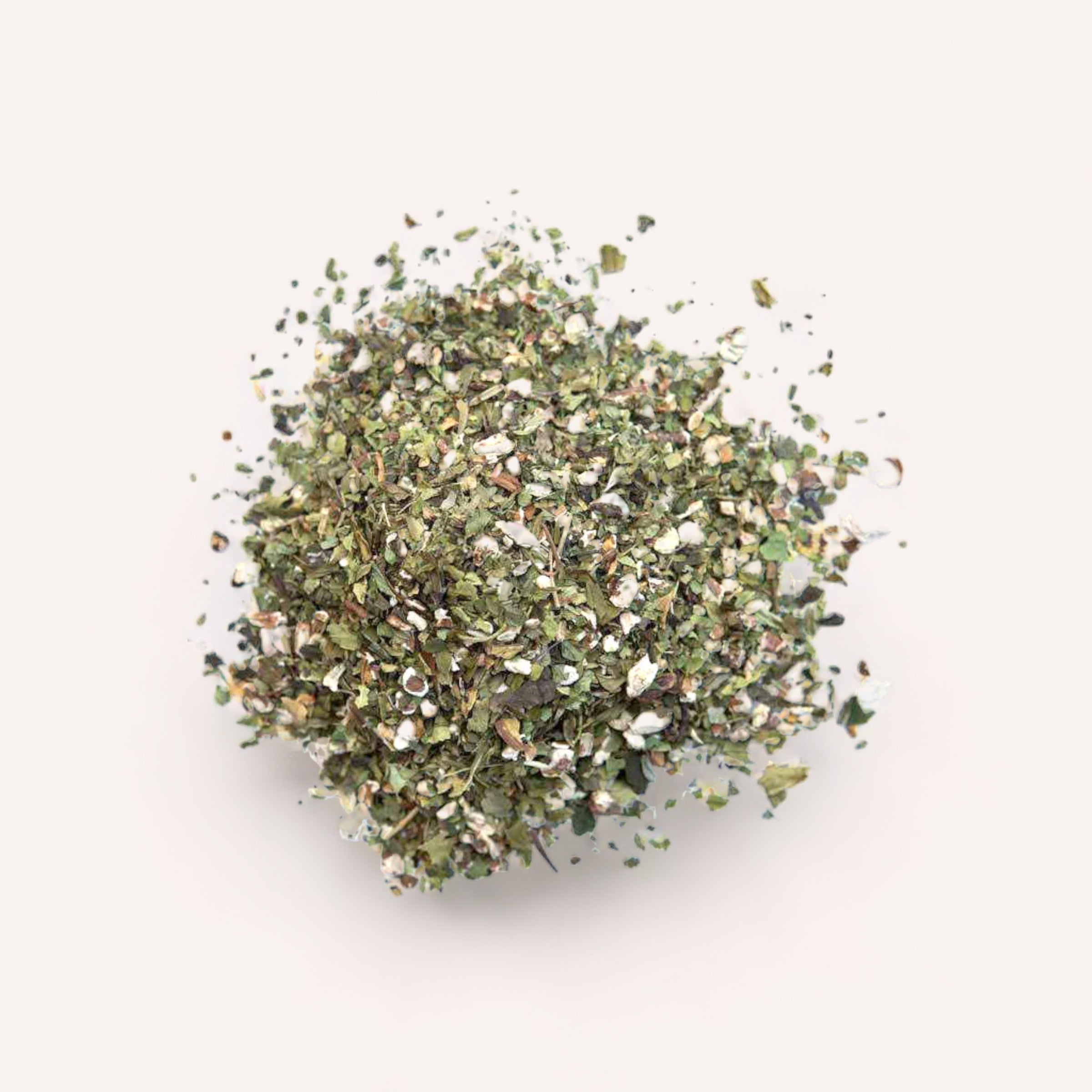 A pile of mixed, nutrient-dense Salvation Tea herbs and spices by Forage + Bloom on a white background.