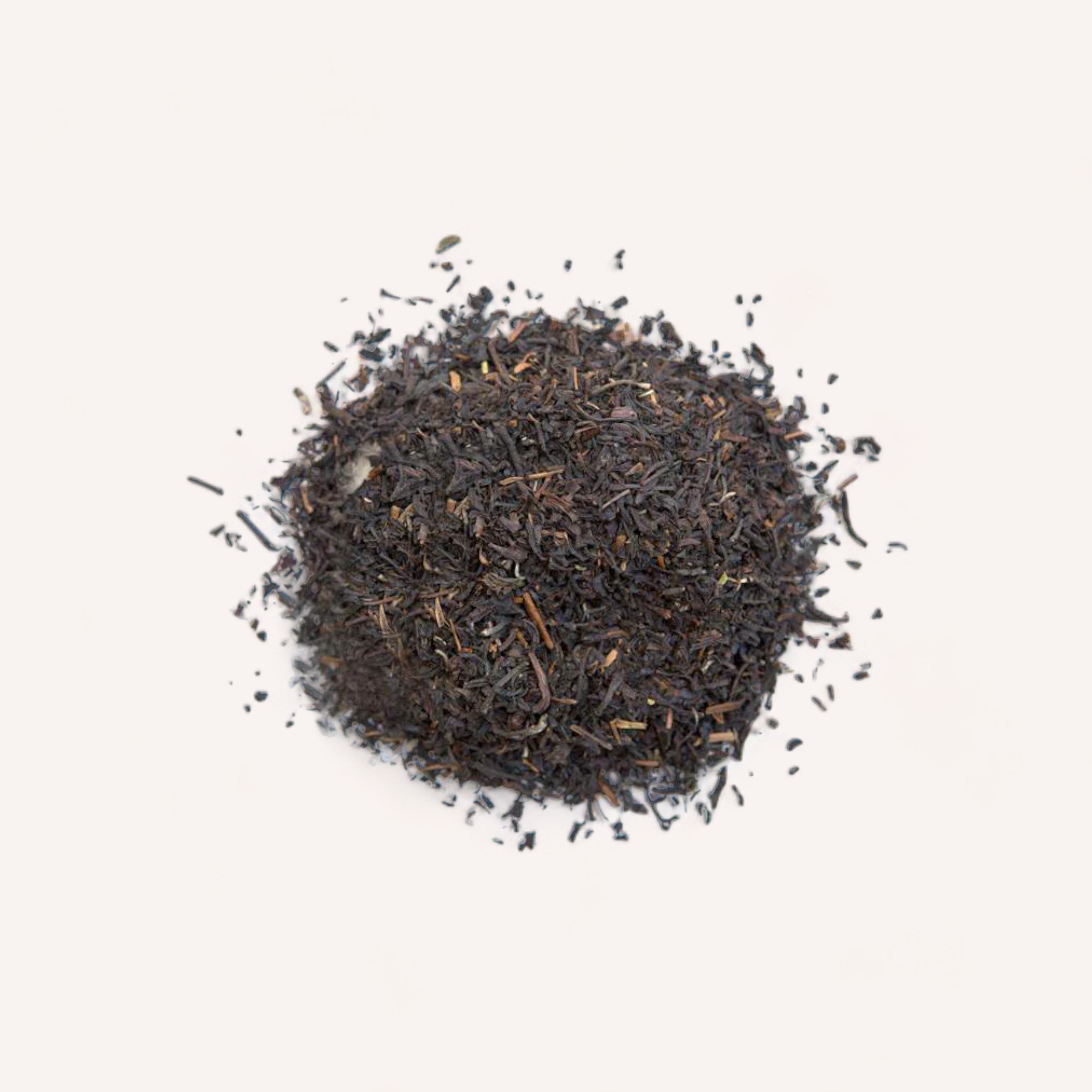 A mound of Earl Grey Tea by Forage + Bloom loose-leaf black tea isolated on a white background.