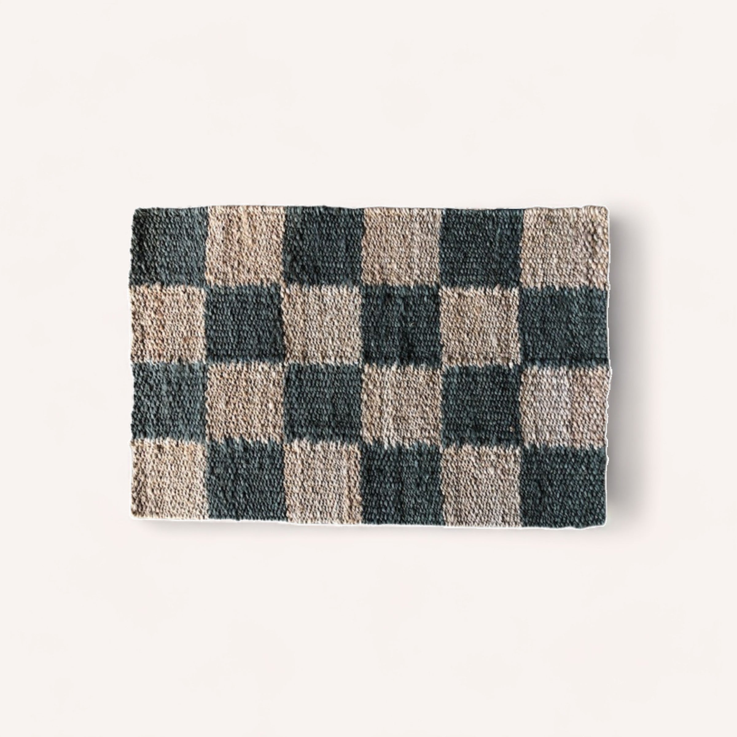 A folded Jute Mat Green Checker blanket by PottedNZ on a white background.