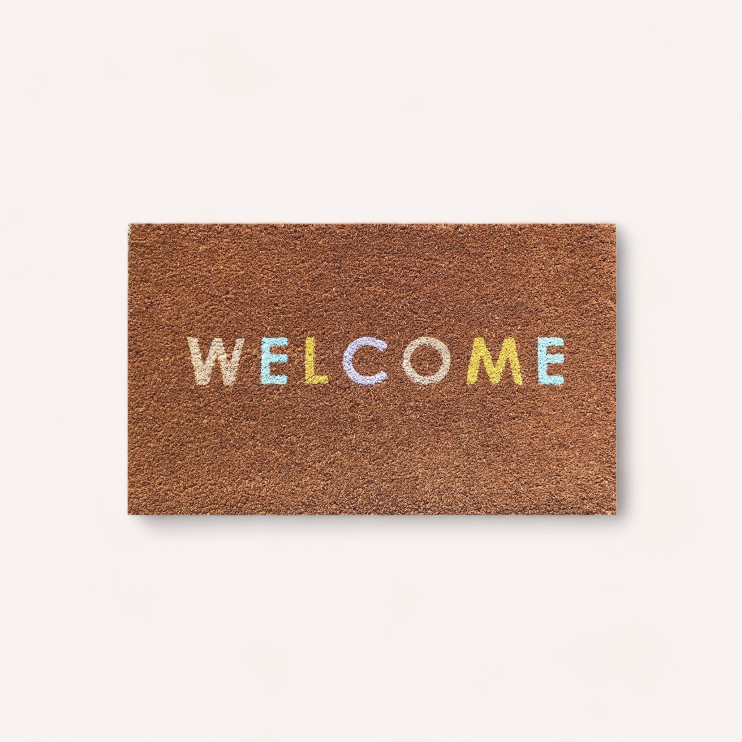 A colorful "welcome" text on a brown coir doormat with rubber backing against a white background, featuring the Welcome Doormat by PottedNZ.