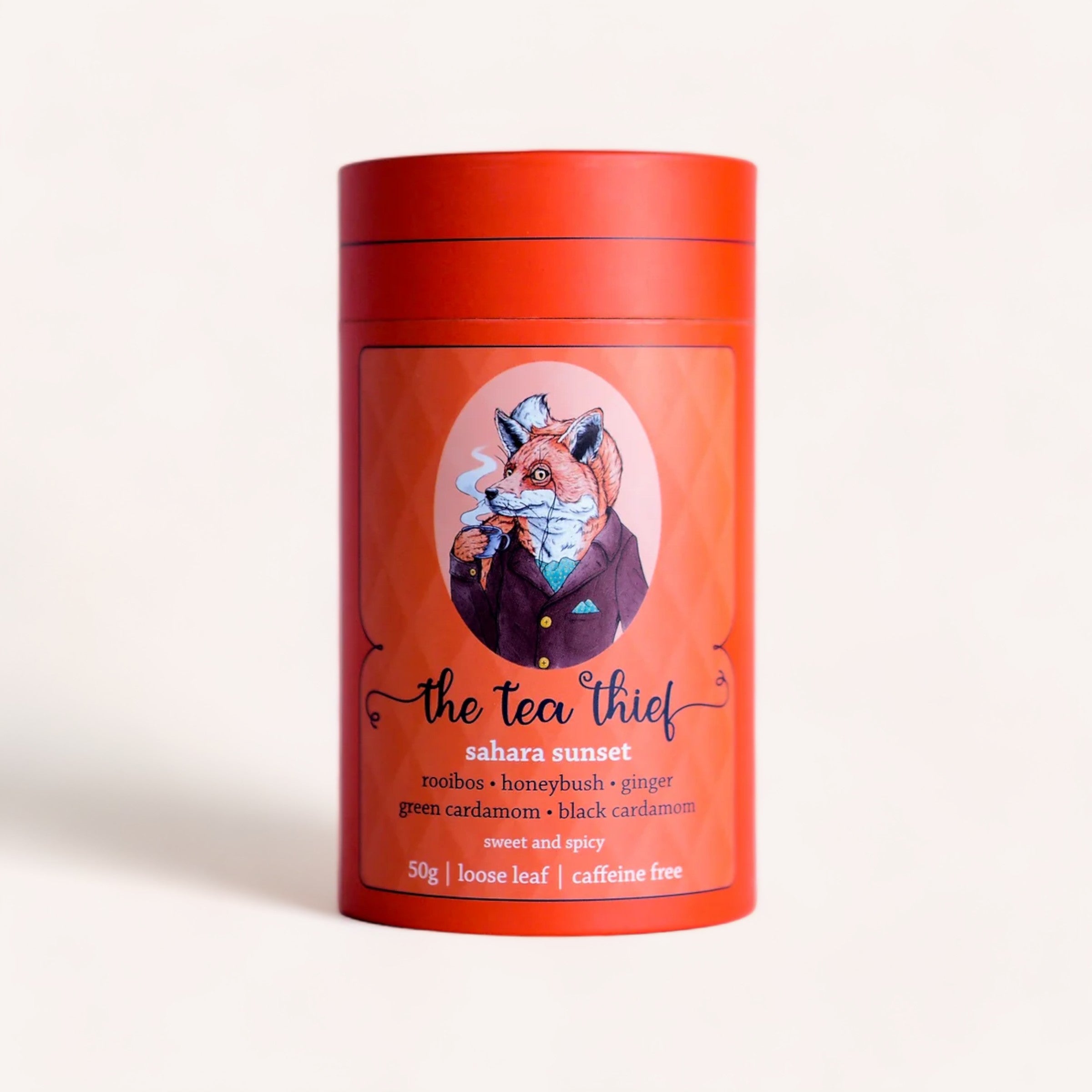 A whimsical tin of "Sahara Sunset 50g by The Tea Thief" loose leaf, caffeine-free tea, featuring rooibos, honeybush, ginger, green cardamom, and.