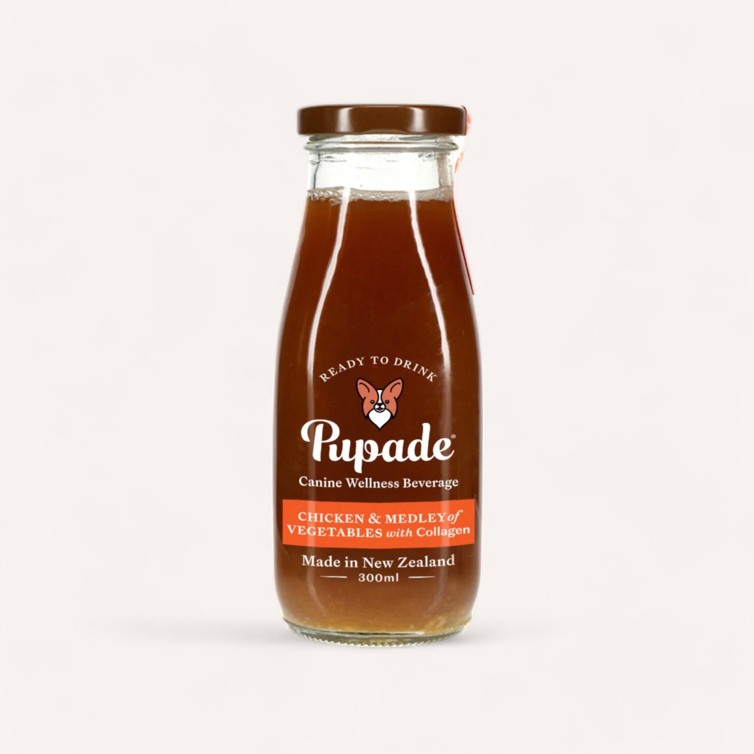 A 300ml glass bottle of Pupade Dog Beverage, highlighted by its dog cartoon logo, hails from New Zealand and is crafted with natural ingredients like chicken and a variety of vegetables enhanced with collagen. This canine wellness drink, with its rich brown liquid, is designed for the discerning dog beverage enthusiasts.