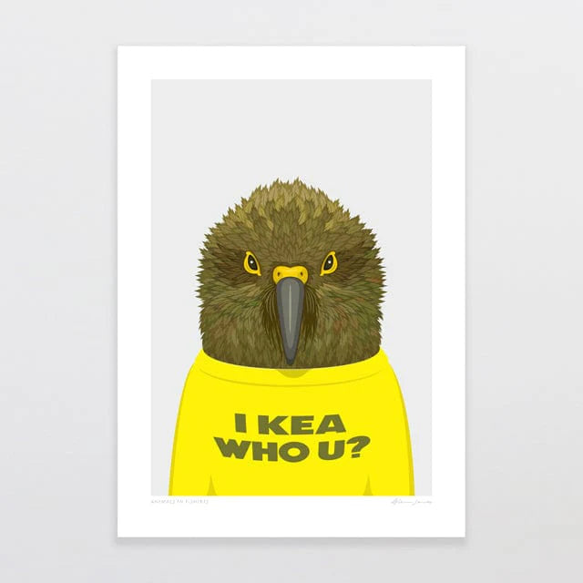 The artwork titled "Animals in T-Shirts - Kea by Glenn Jones" from the Glenn Jones collection features a kea parrot donning a yellow shirt with the words "I KEA WHO U?" printed on it. The bird, with its green and brown feathers, is set against a light gray background and includes a white border around the print.