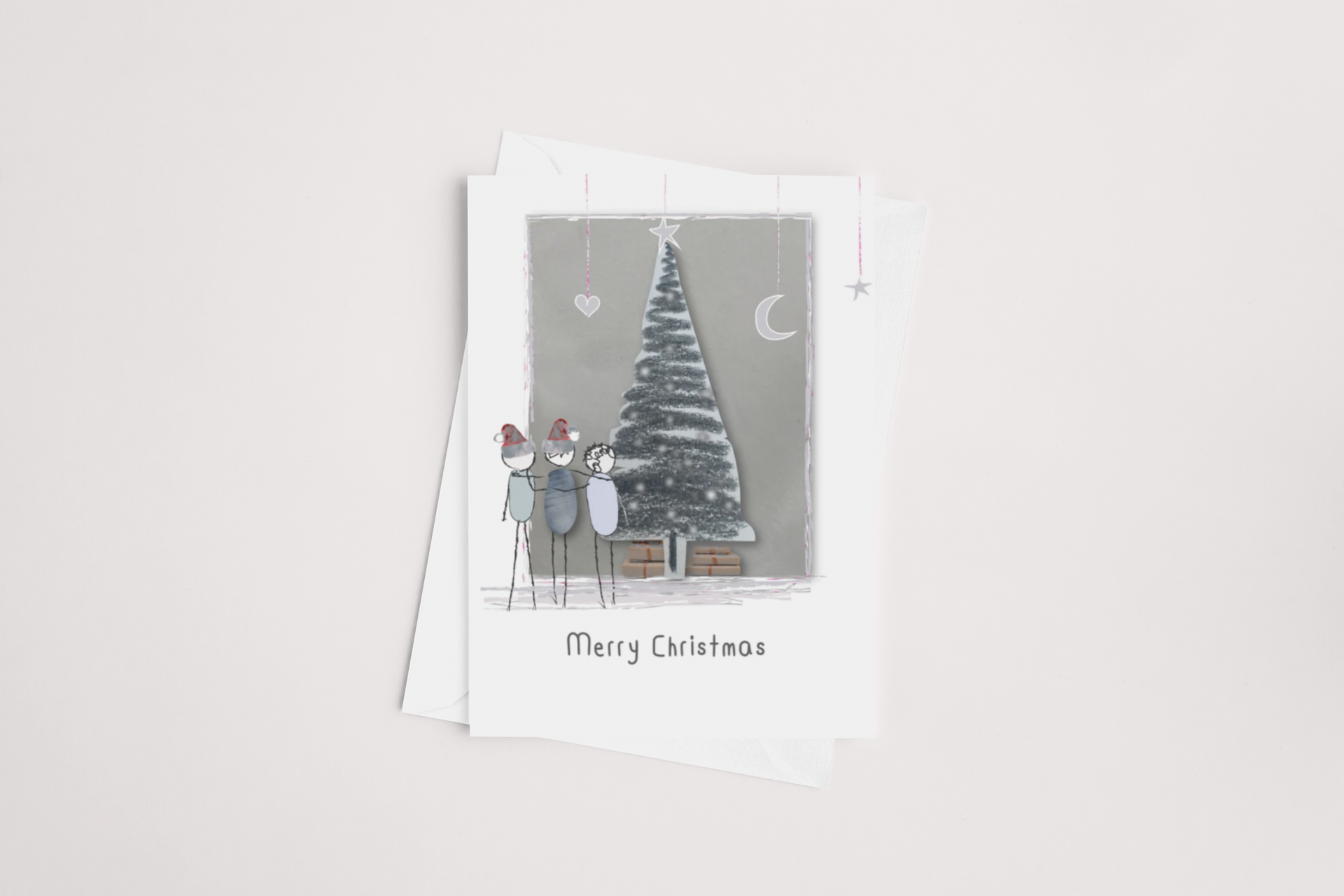 The "Around the Tree Christmas Card" by iCandy showcases a sketched scene of a family of four dressed in winter apparel, standing beside a snow-covered Christmas tree decorated with ornaments. The gray background features a crescent moon and stars, and "Merry Christmas" is elegantly displayed on the front. The interior is left blank for your personal message, and each card includes a white envelope.