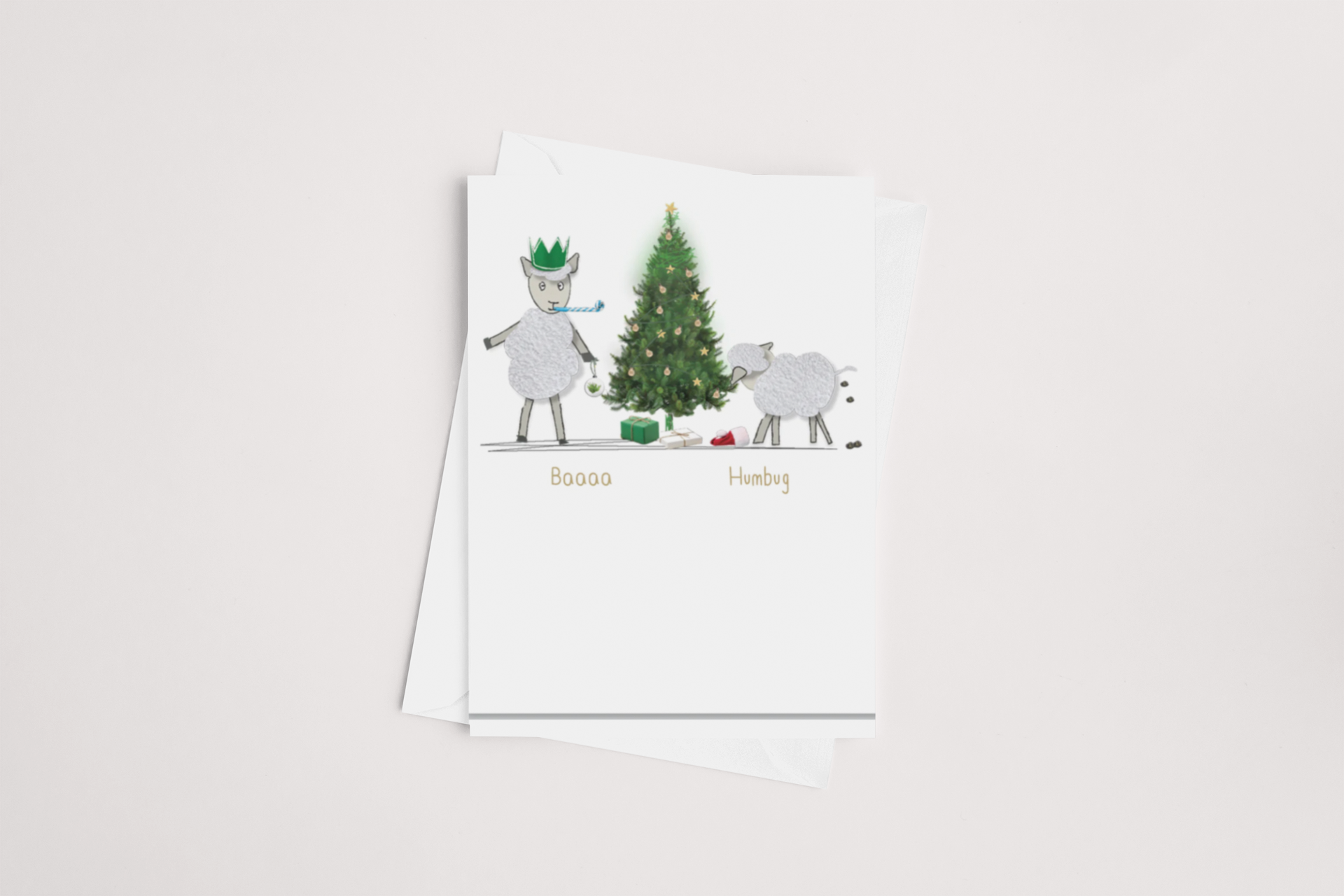 The Baa Humbug Christmas Card by iCandy showcases two cartoon sheep, one donning a green crown, standing next to a festive Christmas tree adorned with ornaments and gifts. The card's front displays the playful message "Baaaa Humbug" against a plain white backdrop. Ideal for conveying your special thoughts, it includes a coordinating white envelope.